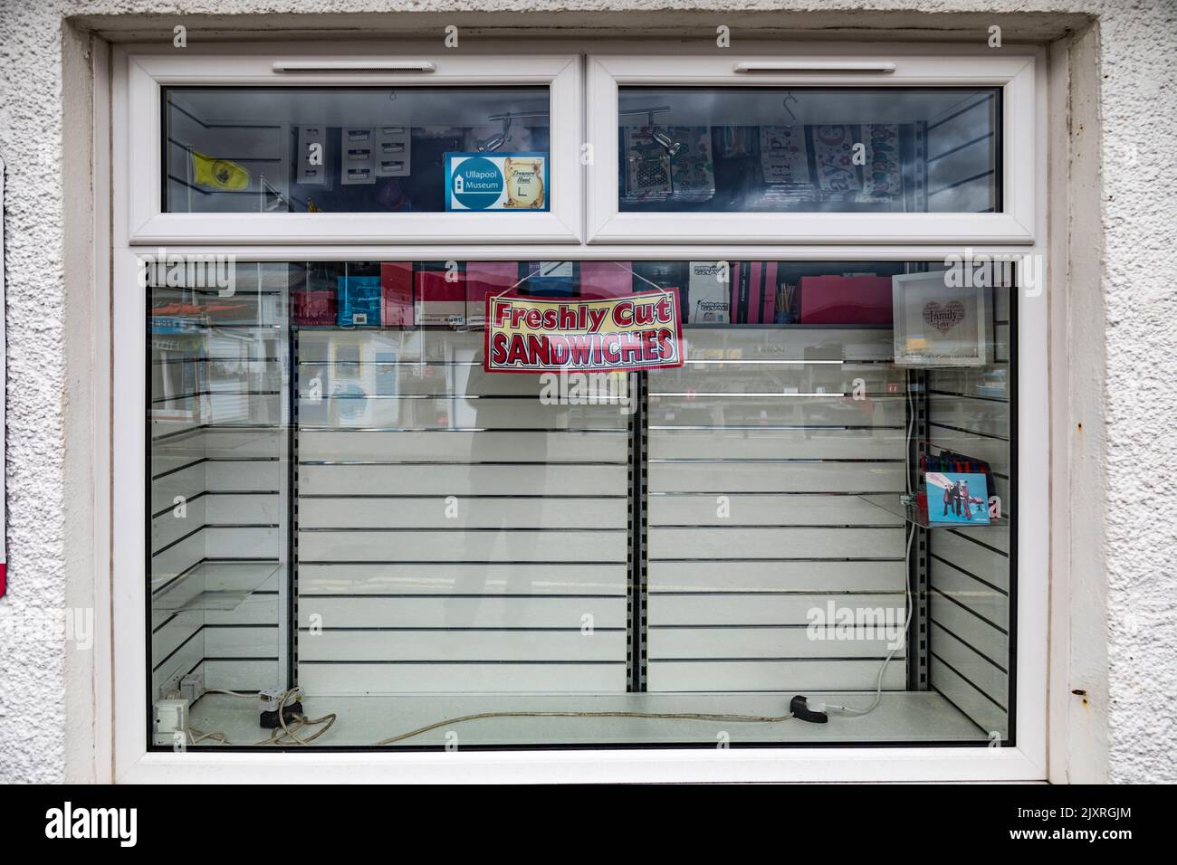 Sign offering 'freshly cut sandwiches' in an empty shop window, Scotland. Stock Photo