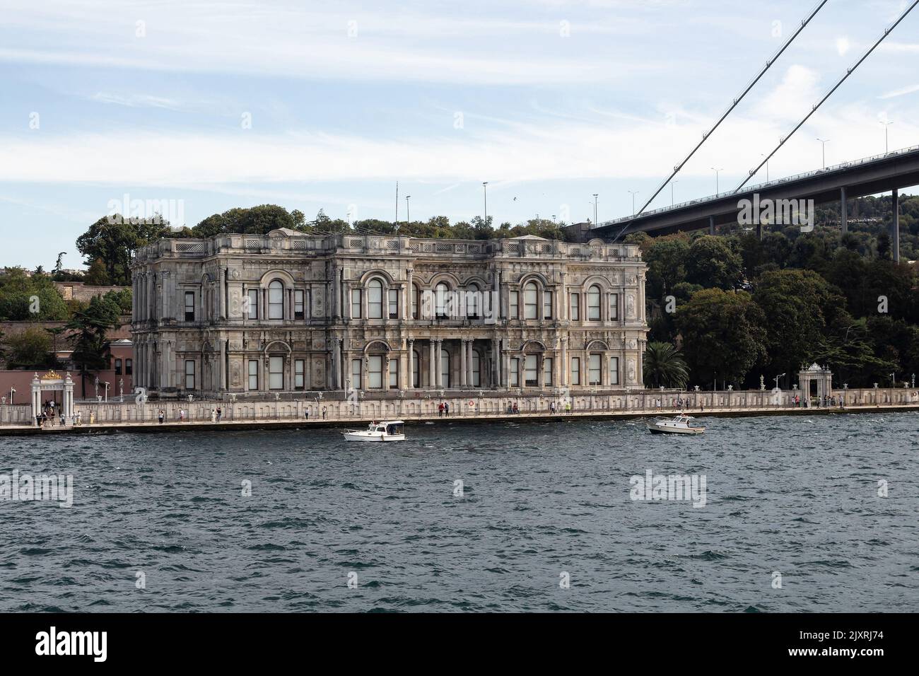 View of small fishing boats on Bosphorus and histrocial palace in Cengelkoy area of Asian side in Istanbul. It is a sunny summer day. Beautiful scene. Stock Photo