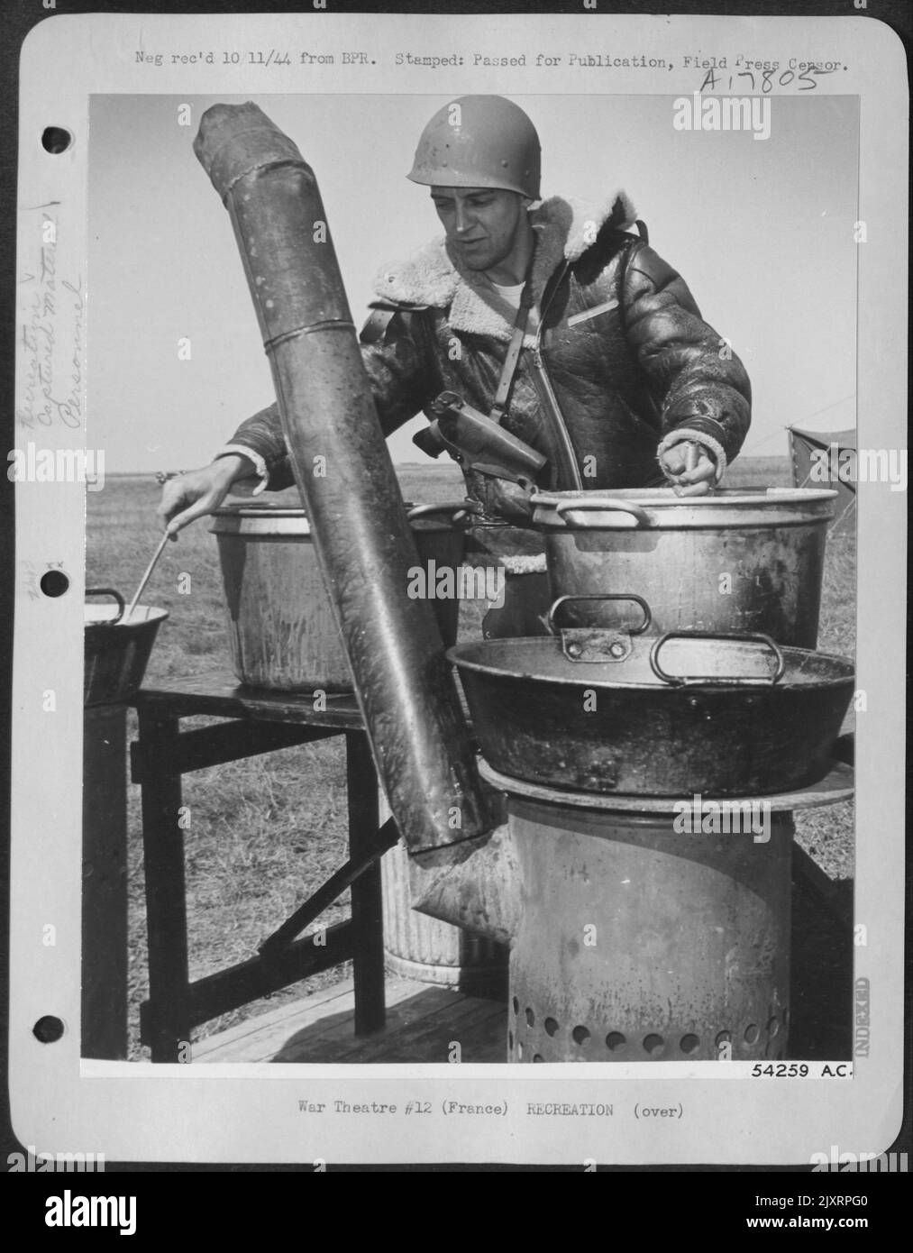 FRANCE-Meals at a captured German field are cooked on a German field range by Sgt Clyde E. Hall, 35, of Dayton, Ohio. Hall and everyone else keep their guns with them all the time because a force of 20,000 Germans under Maj Gen Erich Elster are just Stock Photo