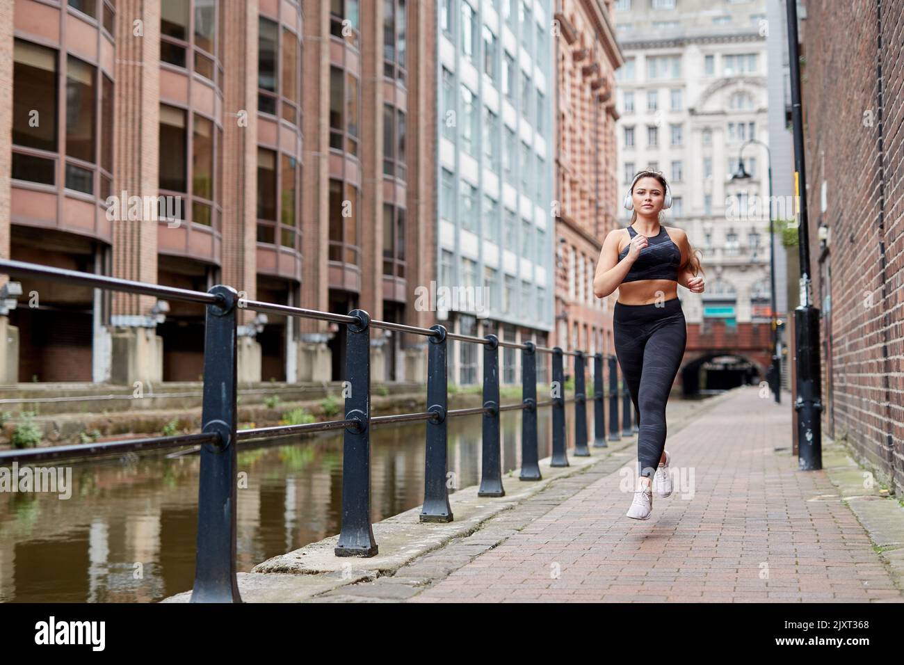 A single female jogger on the streets of Manchester, UK Stock Photo