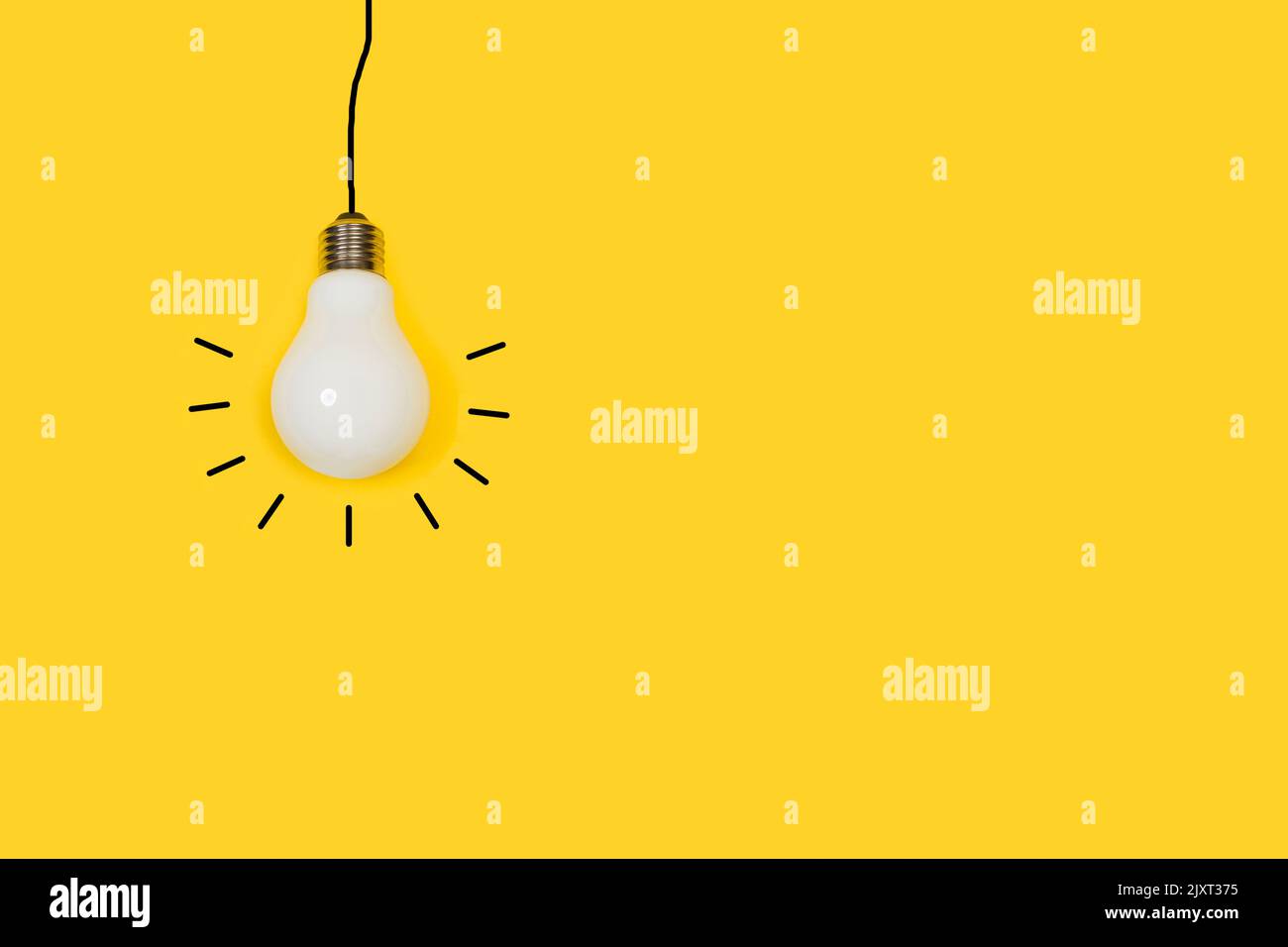 Lightbulb hanging froma black lines cable shape on a yellow background with copy space Stock Photo