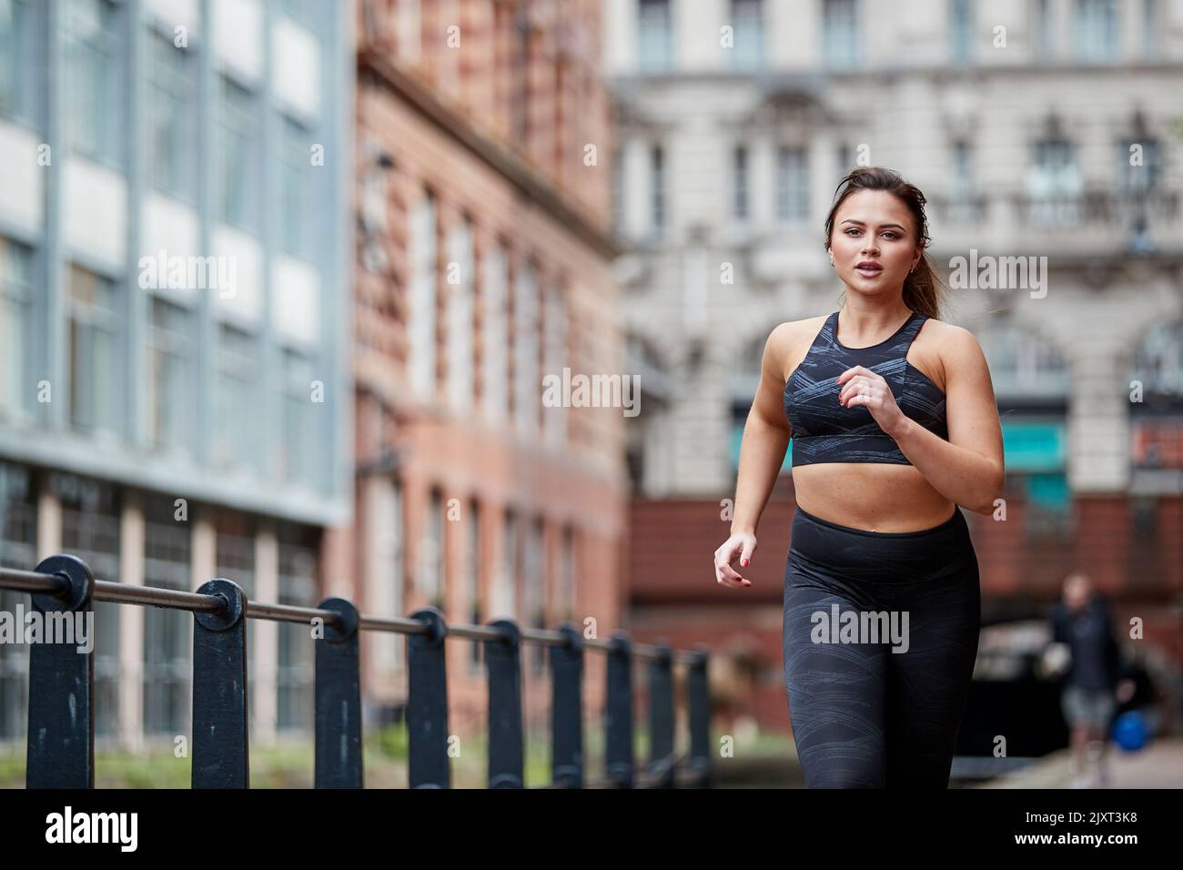 A single female jogger on the streets of Manchester, UK Stock Photo