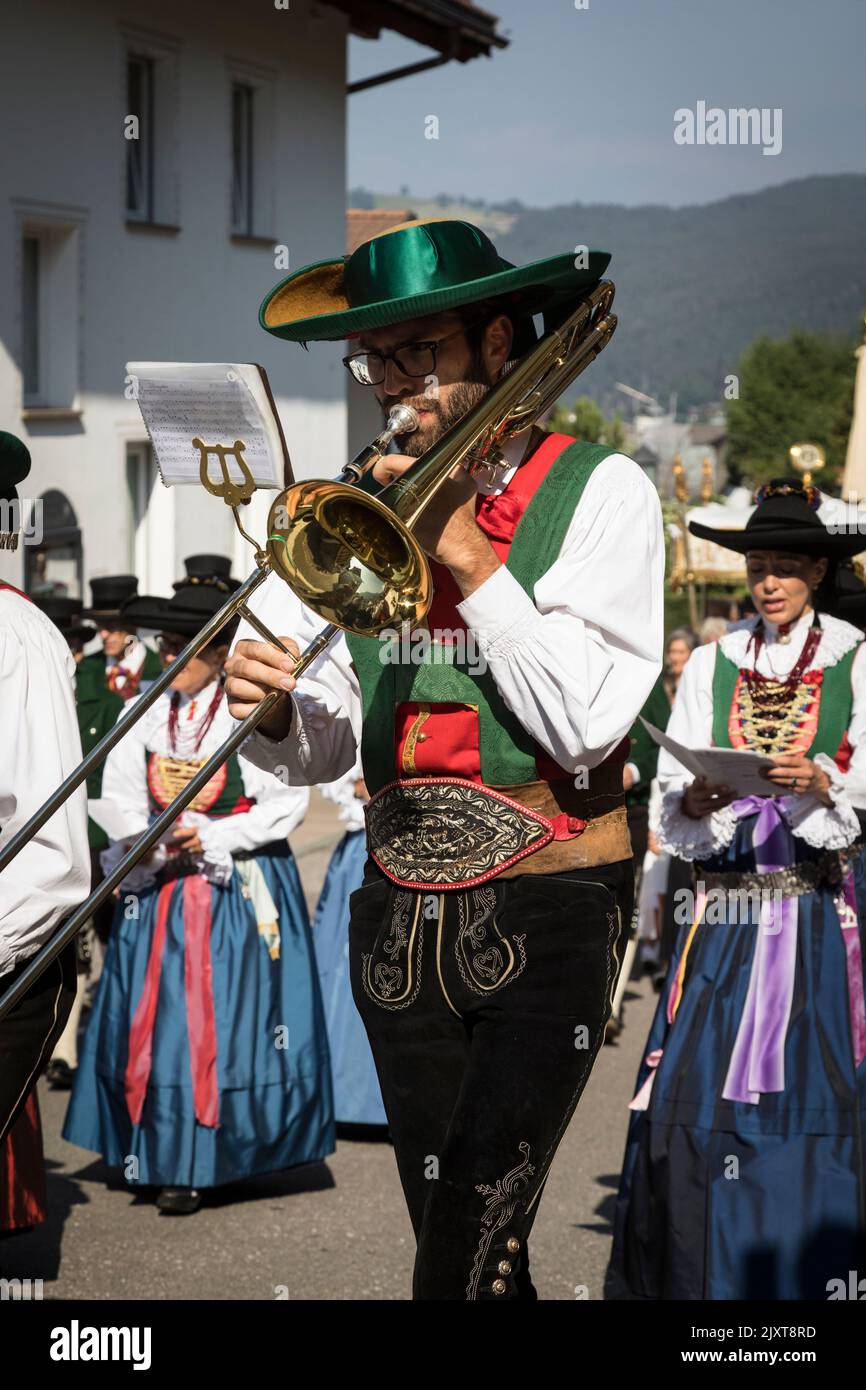 Man playing a trombone and wearing traditional local period costume of