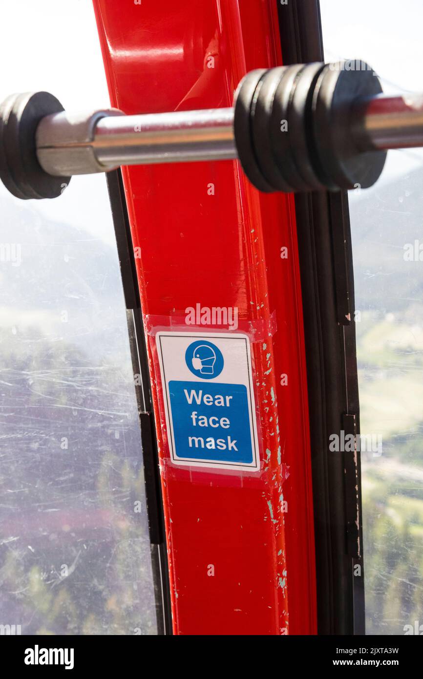'Wear face mask' Covid-19 sticker inside a gondola lift, Italy. Stock Photo