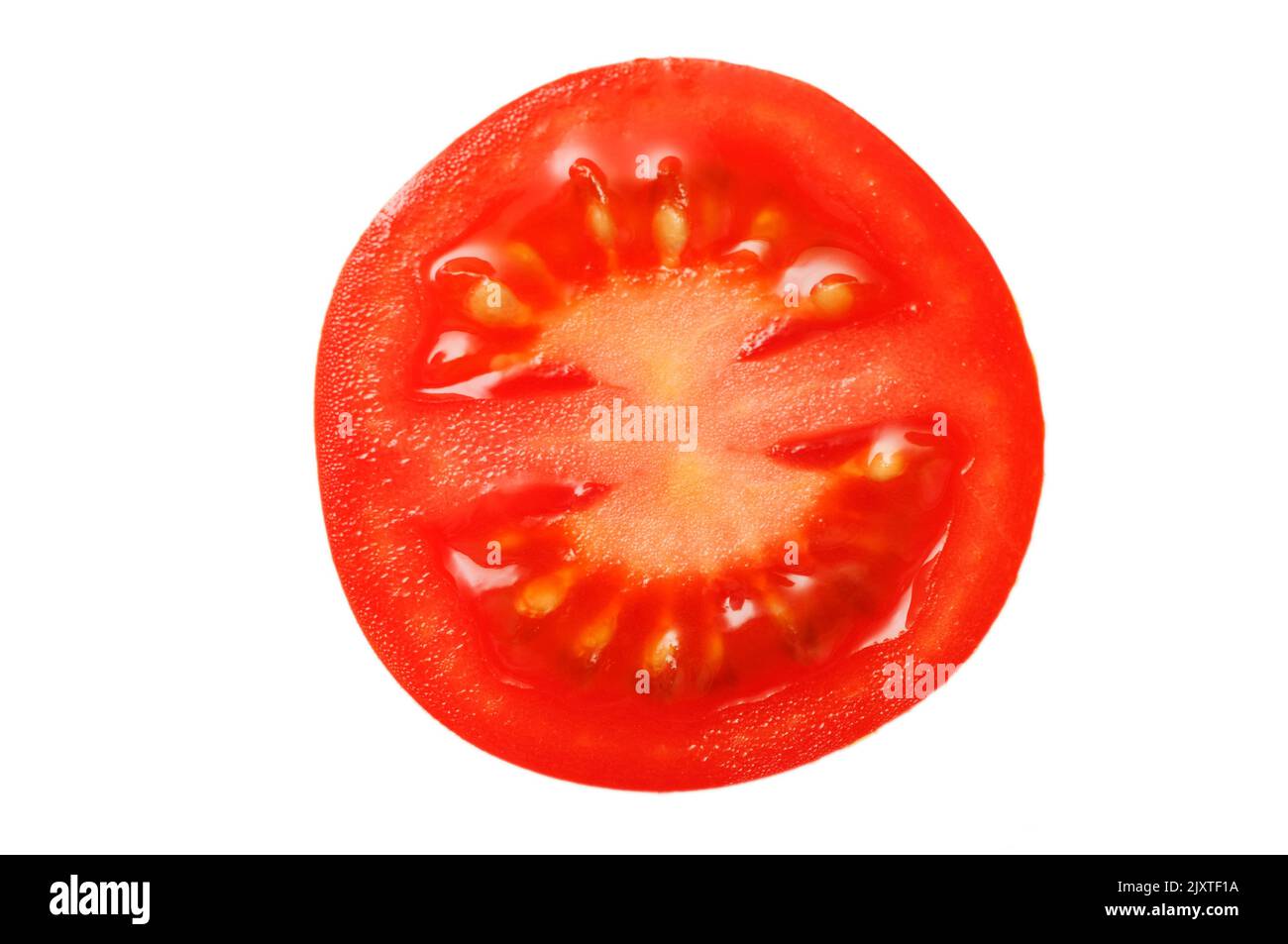 Cross section of a red tomato (lat: Solanum lycopersicum) isolated on white. Stock Photo