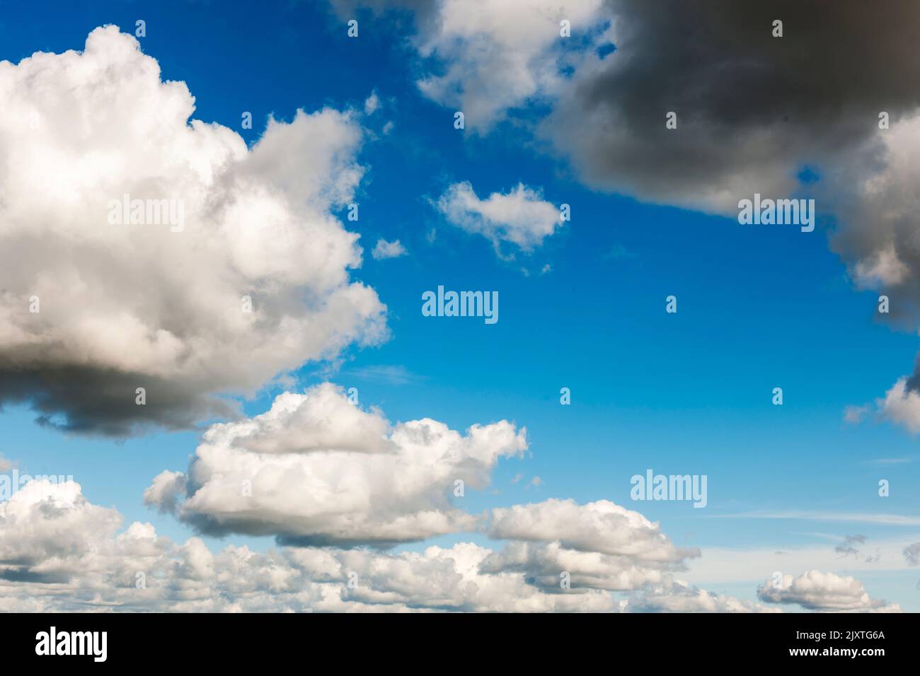 Full-frame landscape view of dark clouds in the blue sky over Europe. Stock Photo