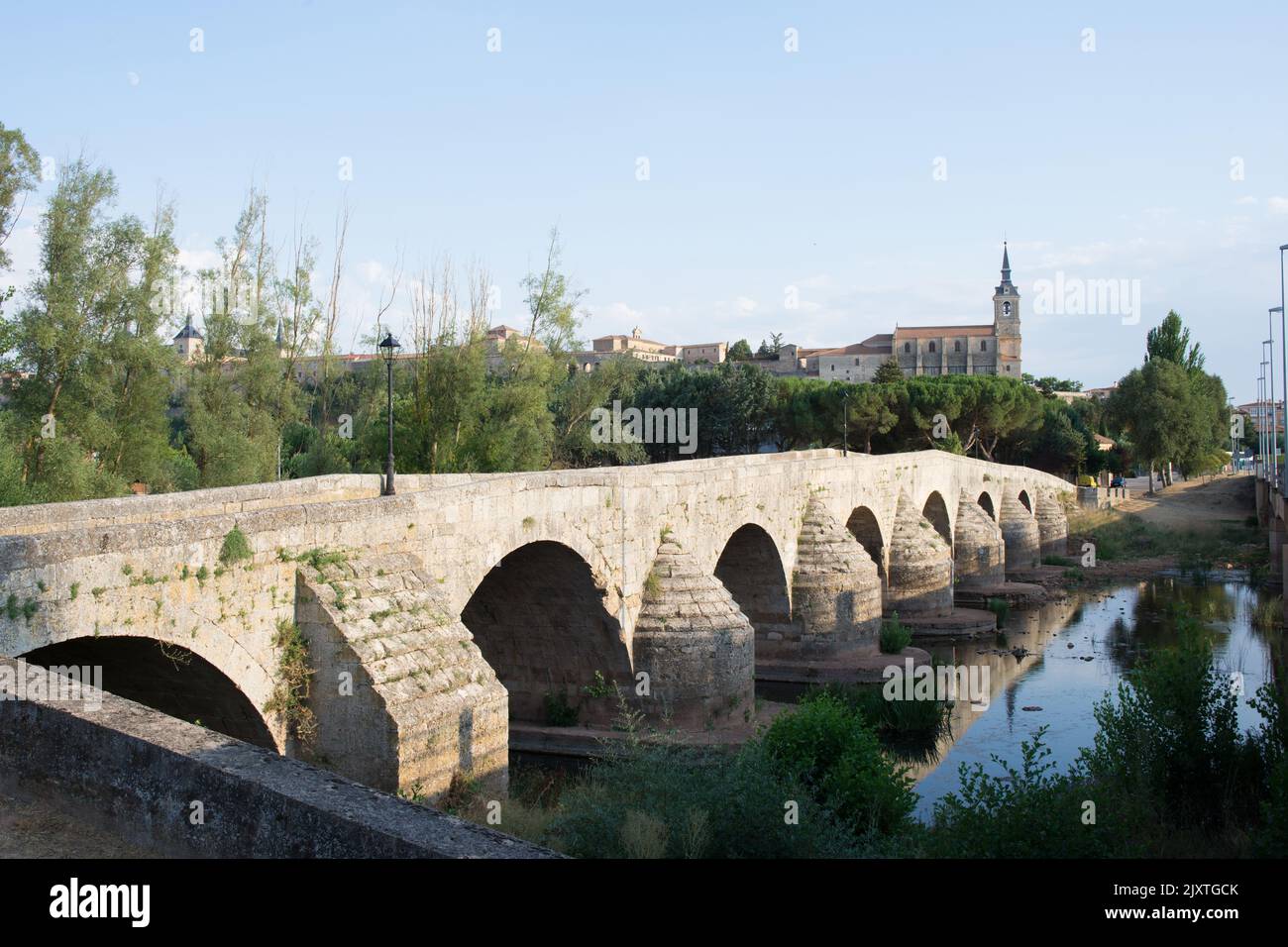 Old stone bridge over Arlanza river at Lerma, Burgos. Collegiate church of San Pedro in the distance. Stock Photo