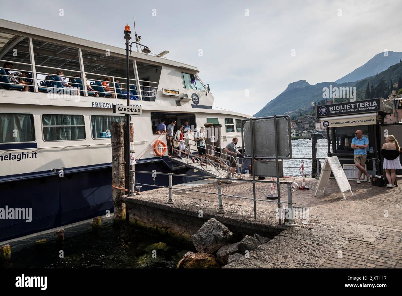 Passengers disembark from a ferry at the dock in Gravedona on Lake Como, Italy. Stock Photo