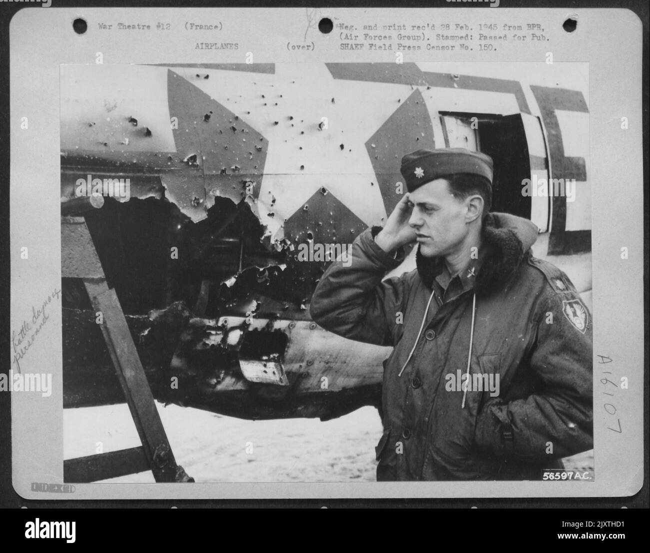 There's a reason for the puzzled expression exhibited by Major Loren W. Herway, Indianola, Iowa, shown examing the damage inflicted on his 9th Air force P-47 Thunderbolt by a direct hit from 88 mm. flak. He's still wondering how the P-47, with Stock Photo