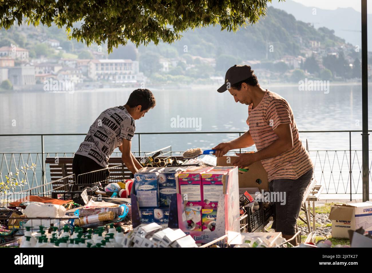 Market traders layout their stall of household goods alongside Lake Como, Italy Stock Photo