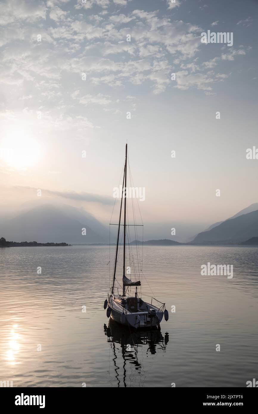 Solitary small yacht on a calm, peaceful morning on Lake Como, Italy. Stock Photo