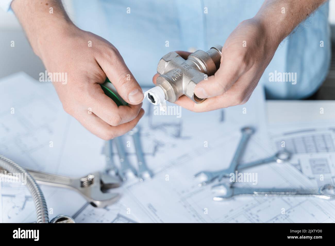 Man repairer,plumber using thread seal tape for reducer sealing
