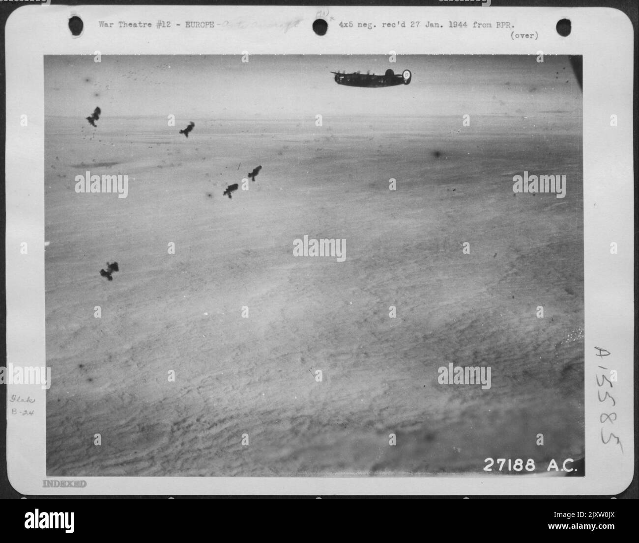 FLAK AHEAD-An American heavy bomber ploughs through heavy flak barrage high above the solid cloud bank through which it is about to unload its bombs onto a Nazi target thousands of feet below. The new technique of 'bombing through clouds' Stock Photo