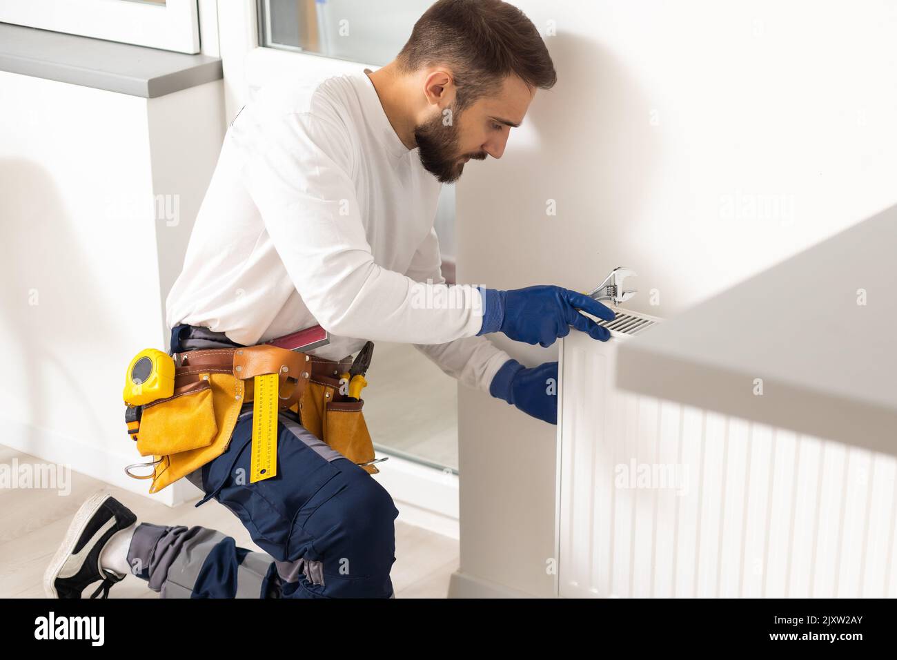 Repair heating radiator closeup. man repairing radiator with wrench