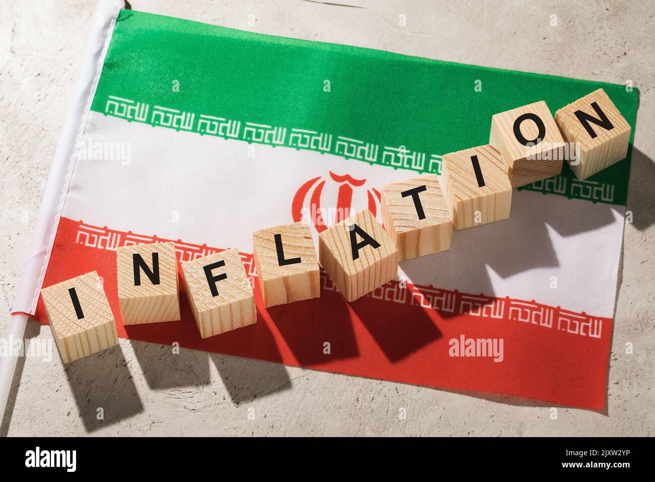 Flag of Iran and wooden cubes with text, a concept on the theme of inflation in the country Stock Photo