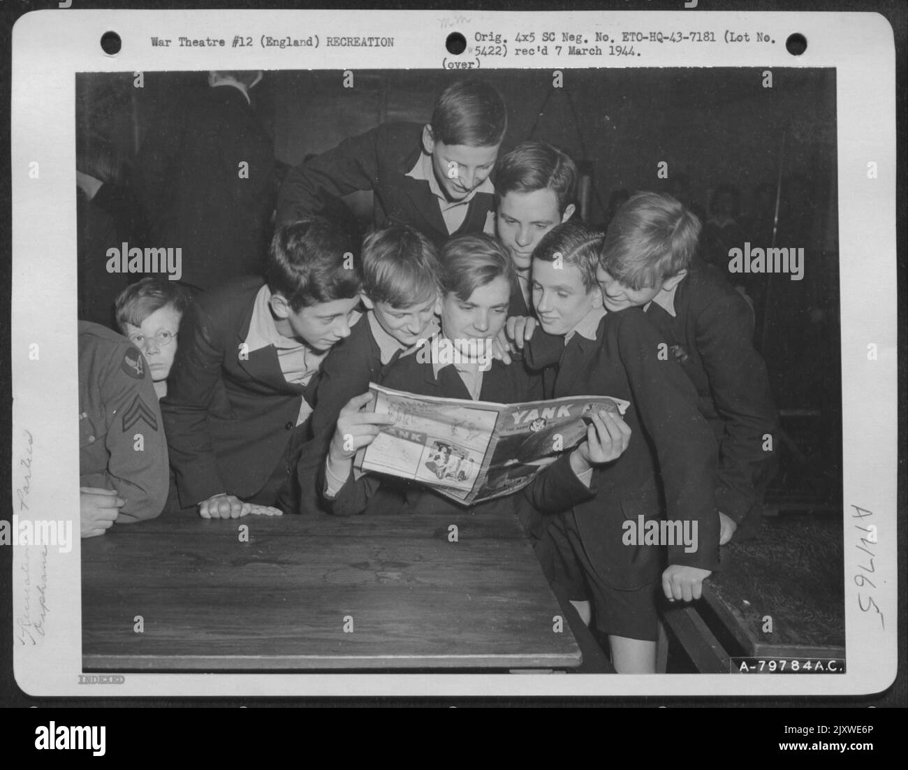 English Orphans Look Through 'Yank' Magazine While Awaiting Transportation To The Movies. The Movies And A Dinner Were Given By U.S. Soldiers At Middlesex, England For The Orphans. 10 October 1943. Stock Photo