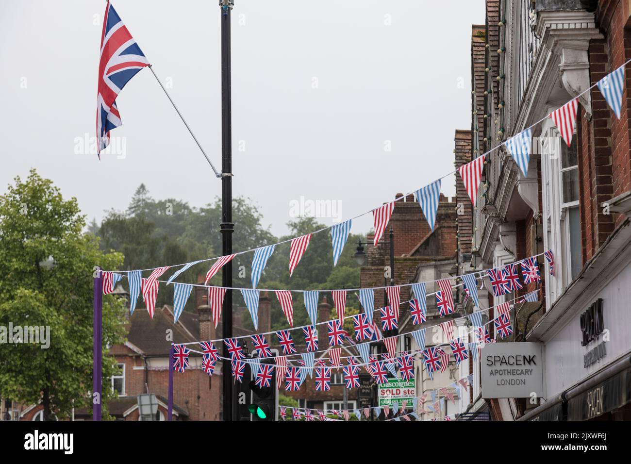 Bunting of Union flags stretch over the pavement in Haslemere to celebrate the Queen's Platinum Jubilee. Stock Photo