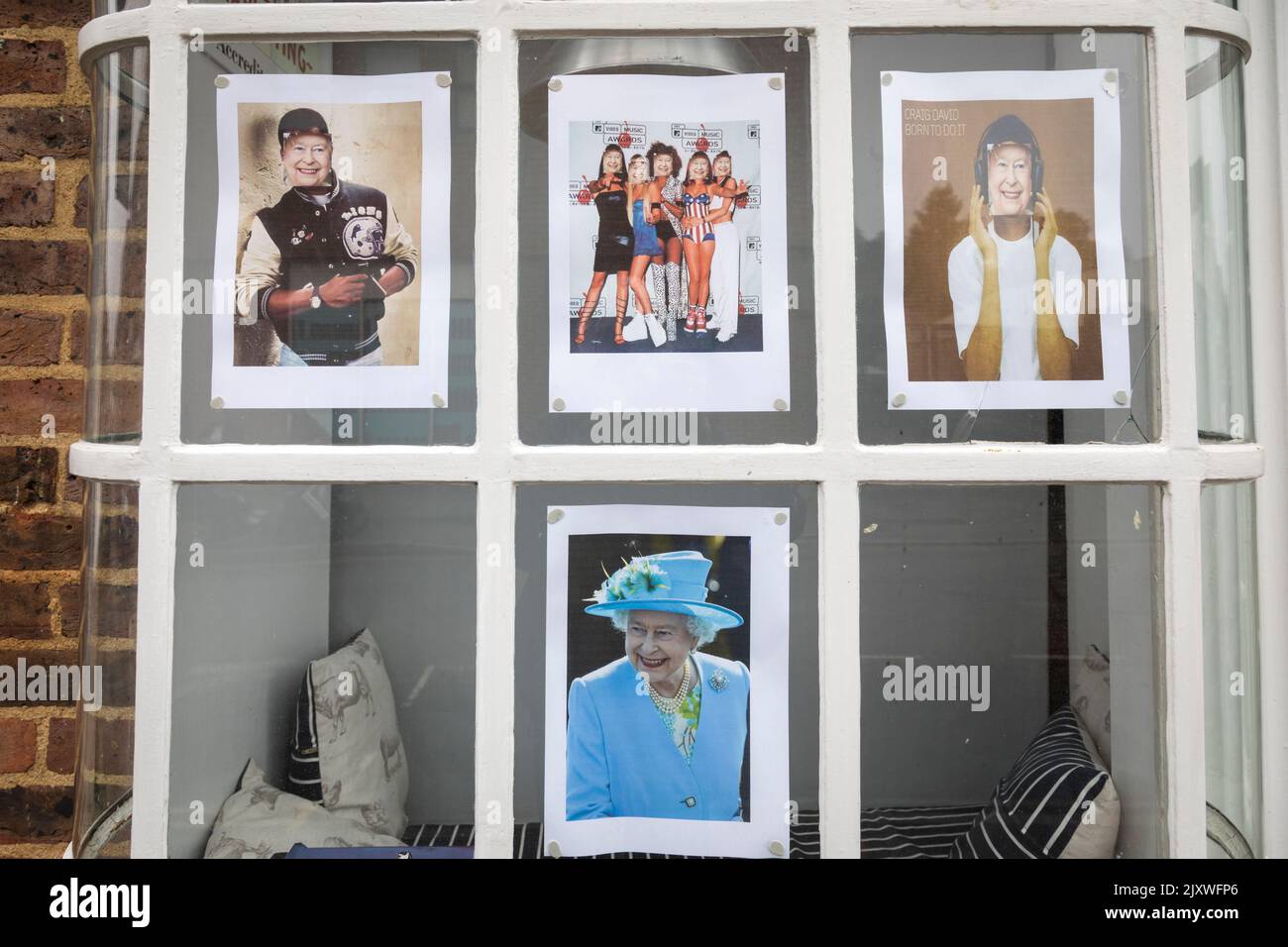 Shop window displaying humorous images of the Queen in celebration of her Platinum jubilee. Stock Photo