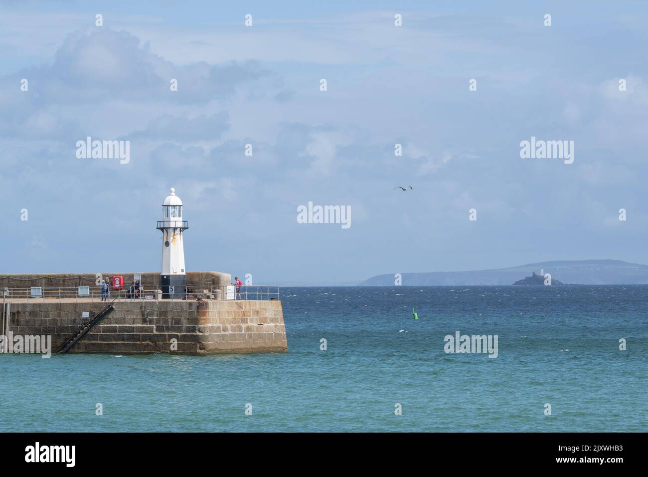 St Ives, Cornwall, UK. 7th Sep, 2022. UK Weather: Looking out towards St Ives Lighthouse on Smeaton's Pier on a day of warm sunny spells and heavy downpours at the picturesque seaside resort of St Ives in Cornwall. The mixed weather is set to remain this week as low pressure systems sweep across the South West of England. Credit: Celia McMahon/Alamy Live News Stock Photo