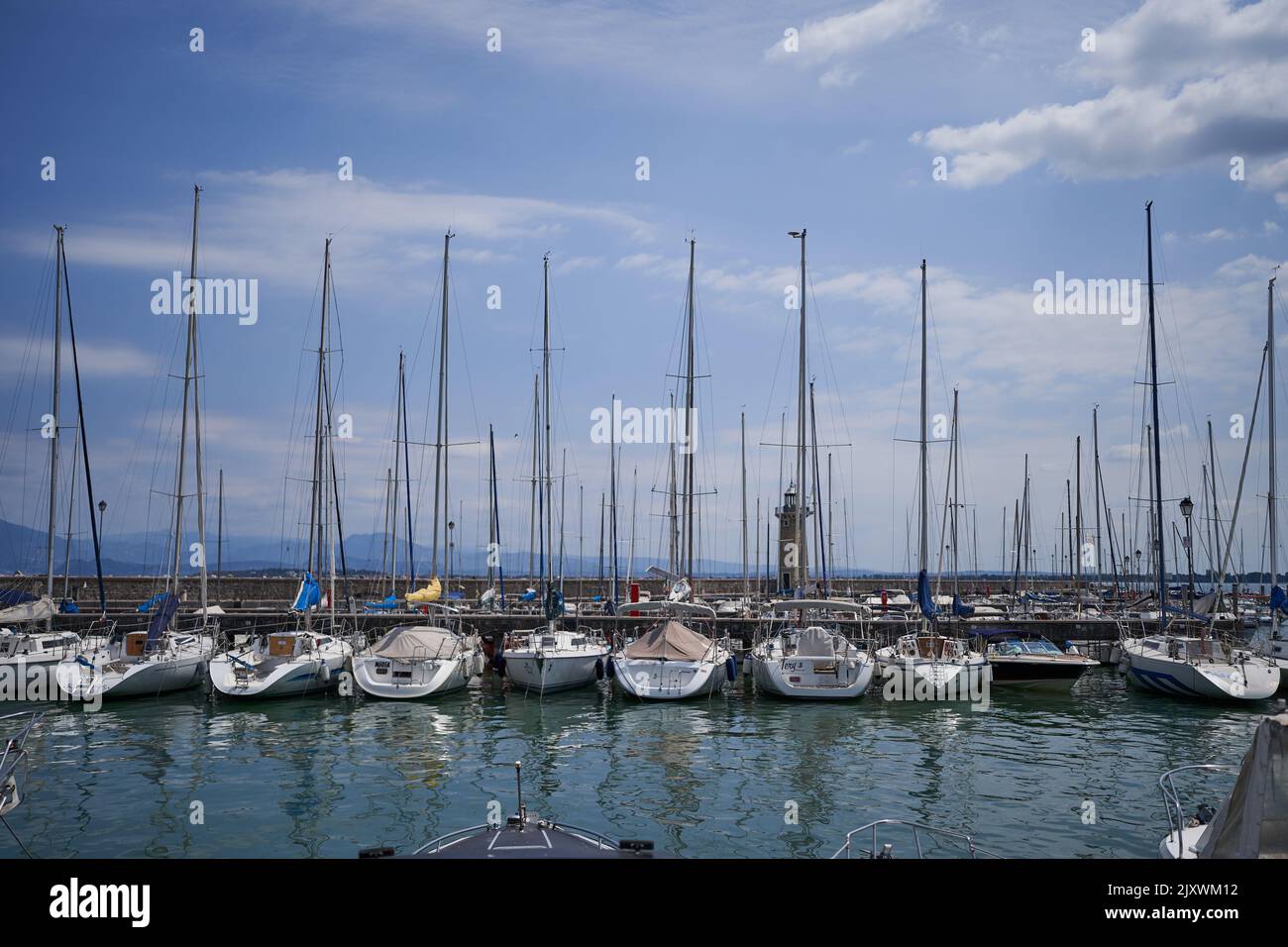 Desenzano del Garda, Italy - July 12, 2022 - yachts and boats docked at the port on Lake Garda on a sunny summer morning Stock Photo
