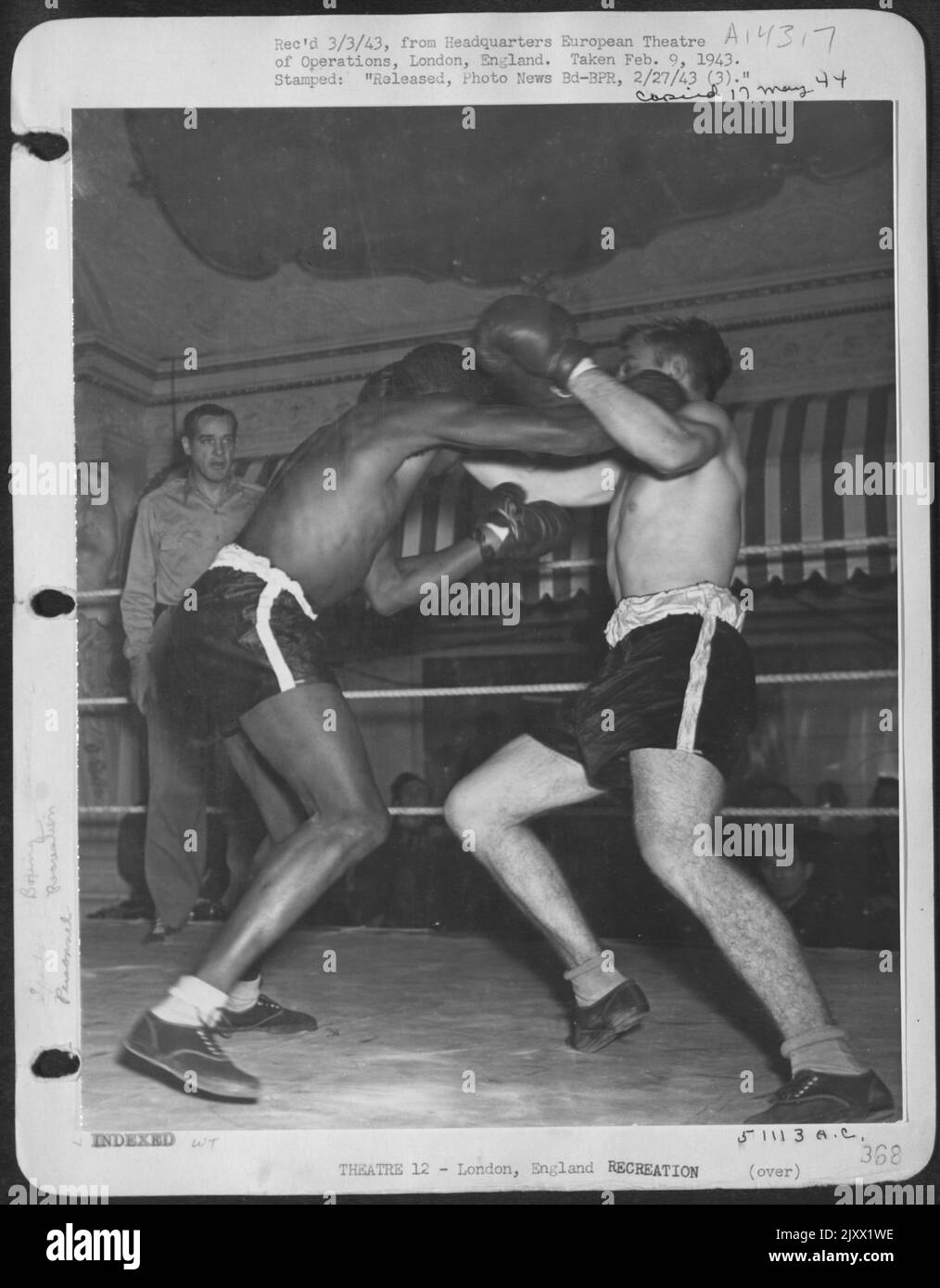 Price fighting at a red cross club somewhere in England. Pvt. Rend Davis, Grand Rapids, Mich., (colored) and Pvt. Keneth O. Taylor, Lexington, S.C., both of the 145-lb. class, slugging it out. Davis won by a technical knockout. London, England. Stock Photo