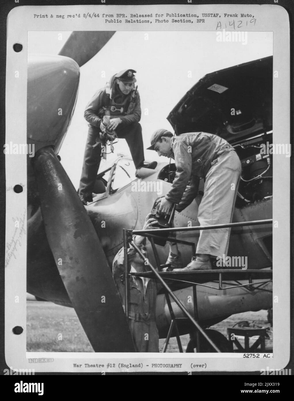 As soon as the plane has stopped moving, and before the pilot, 2nd Lt. Donald A. Schultz, 24, of 2049 N. Stocc St., Melrose Park, Ill., has jumped to the ground, S/Sgt. Charles J. Mader, 30, of 100 Buchanan St., Topeka, Kansas and Cpl. Morris Berkoff Stock Photo