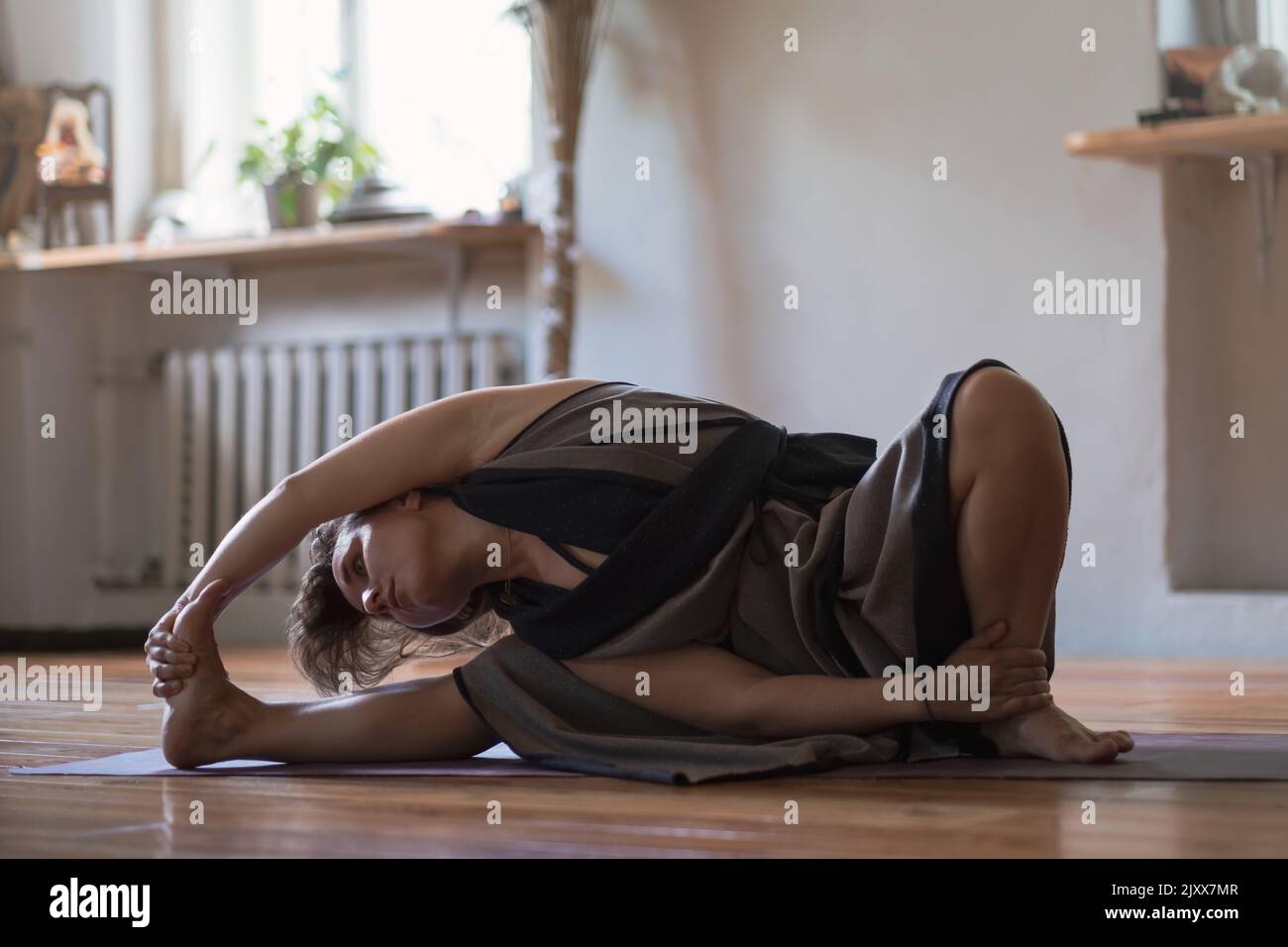 Caucasian woman practicing yoga lesson, breathing, doing twisted exercise, working out, indoor close up. Well being, wellness concept Stock Photo