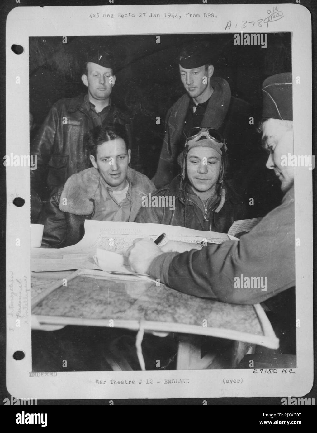 HIS TOUR OF MISSIONS COMPLETED: 1st Lt. Leroy Faringer (wearing goggles) sits for final interrogation on his return from a bombing mission over northwest Germany on 22 Dec. Lt. Faringer, 27, of Texarkana, Texas, is navigator of ofrtress 'Demo Stock Photo