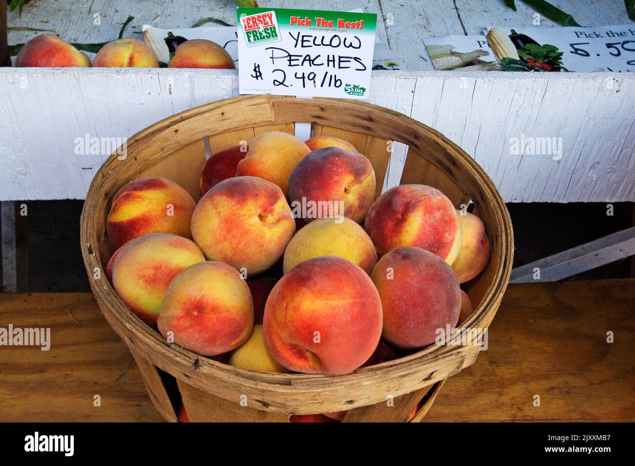 Farm stand with basket of peaches Stock Photo