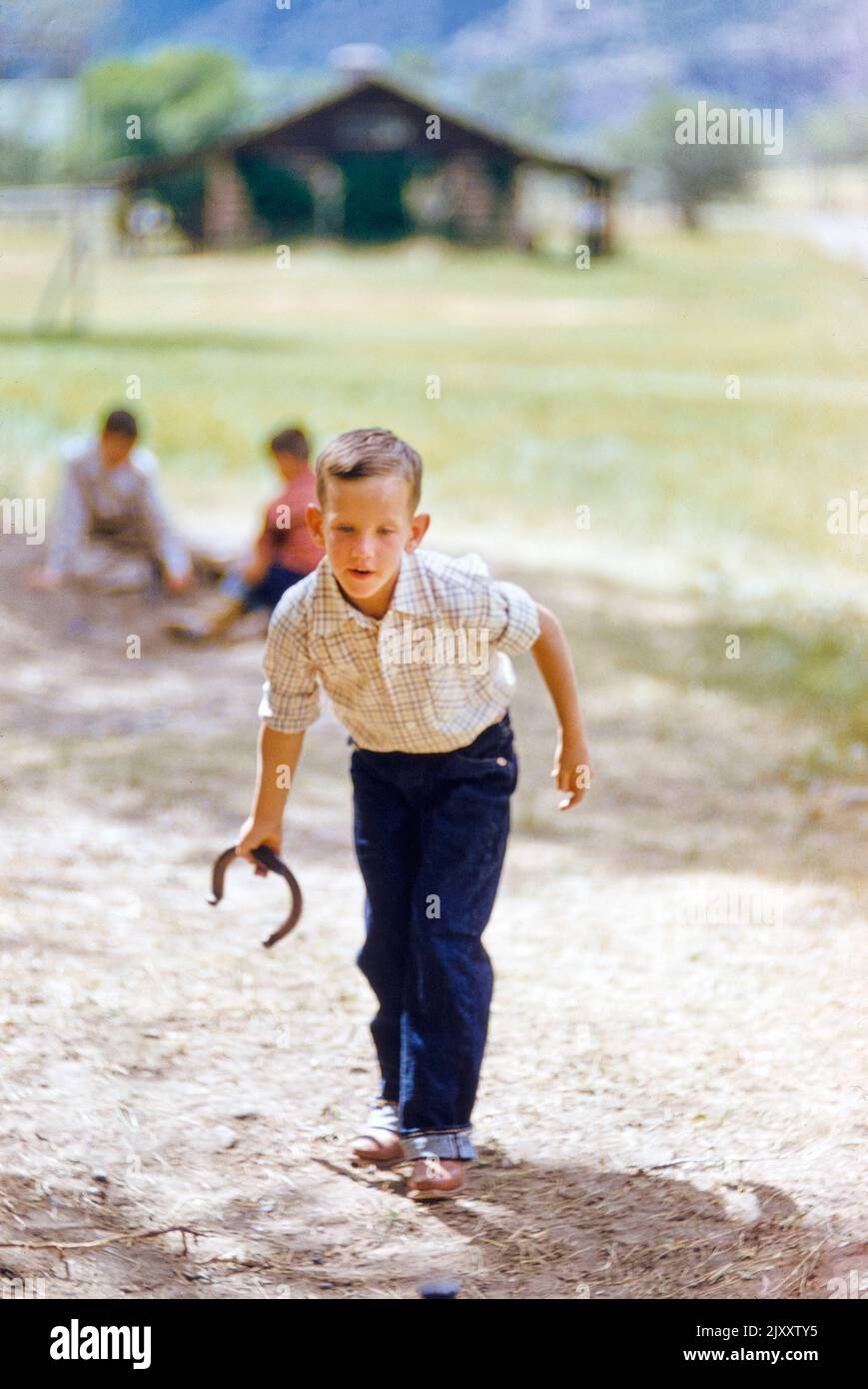 Young boy playing Horseshoes, Star Valley Ranch, Wyoming, USA, Toni Frissell Collection, August 1955 Stock Photo
