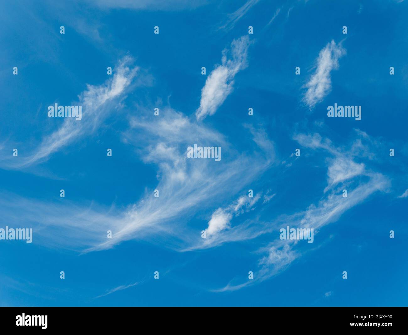 High wispy white cirrus mare's tail clouds against blue sky, UK Stock Photo
