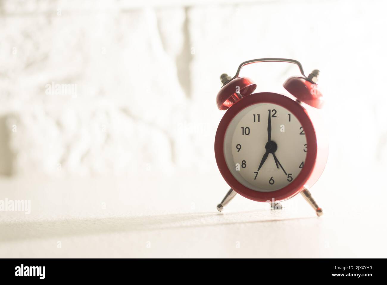 Retro alarm clock with seven o'clock. Old style filtered photo Stock