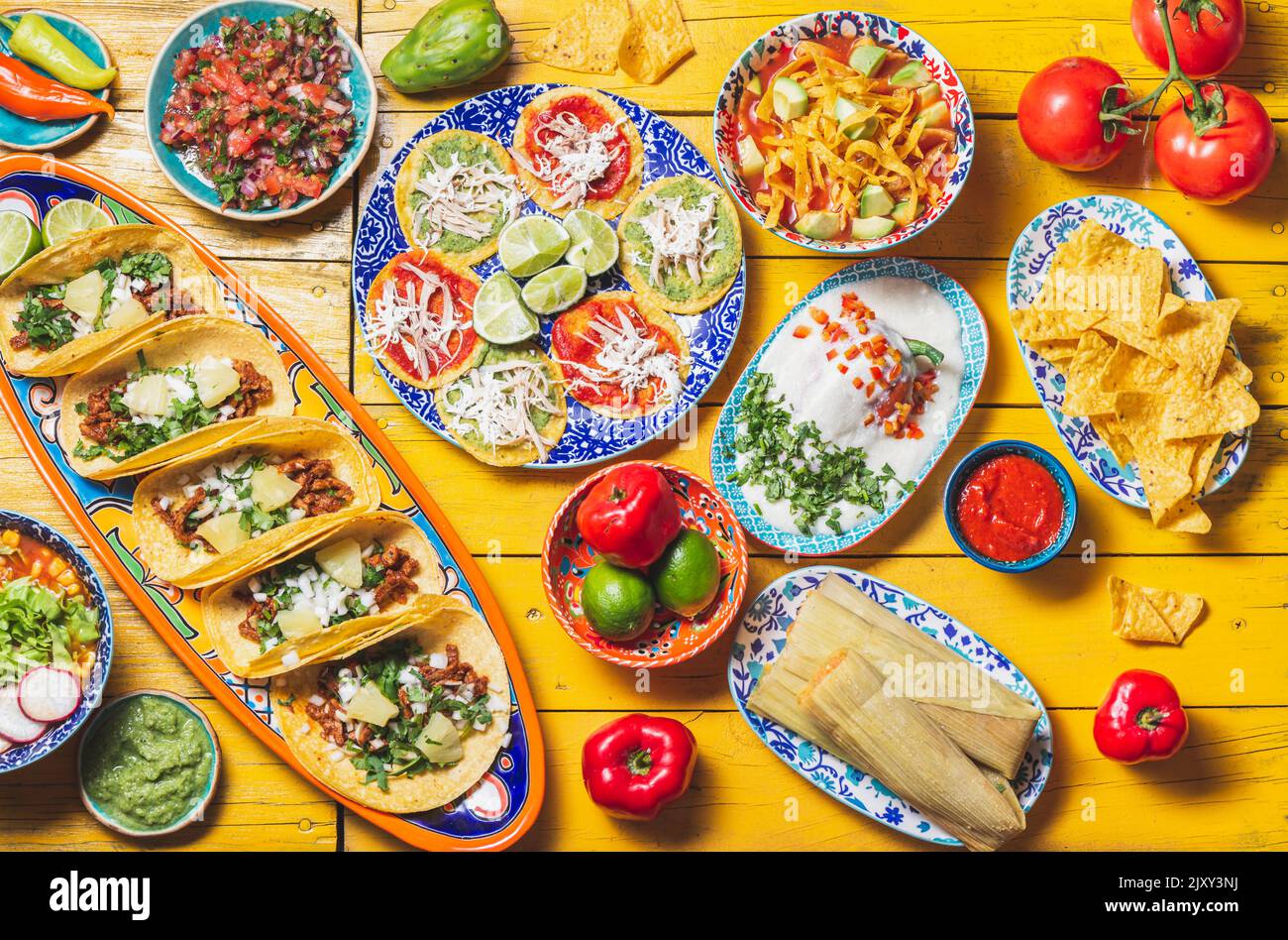 Mexican festive food for independence day - independencia chiles en nogada, tacos al pastor, chalupas pozole, tamales, chicken with mole poblano sauce Stock Photo