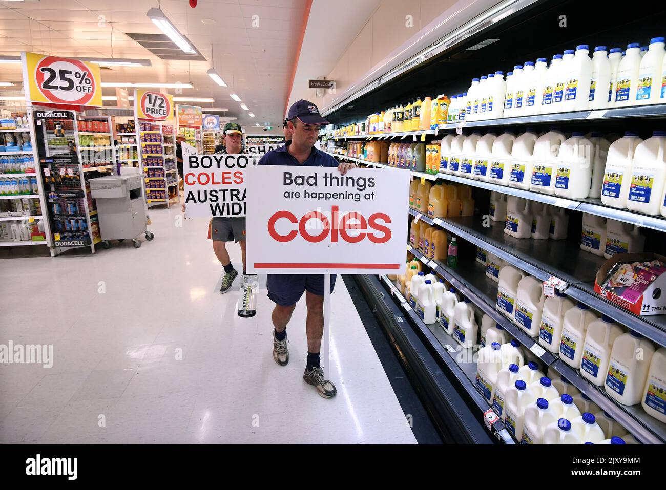 Queensland dairy farmers protest inside a Coles supermarket store in