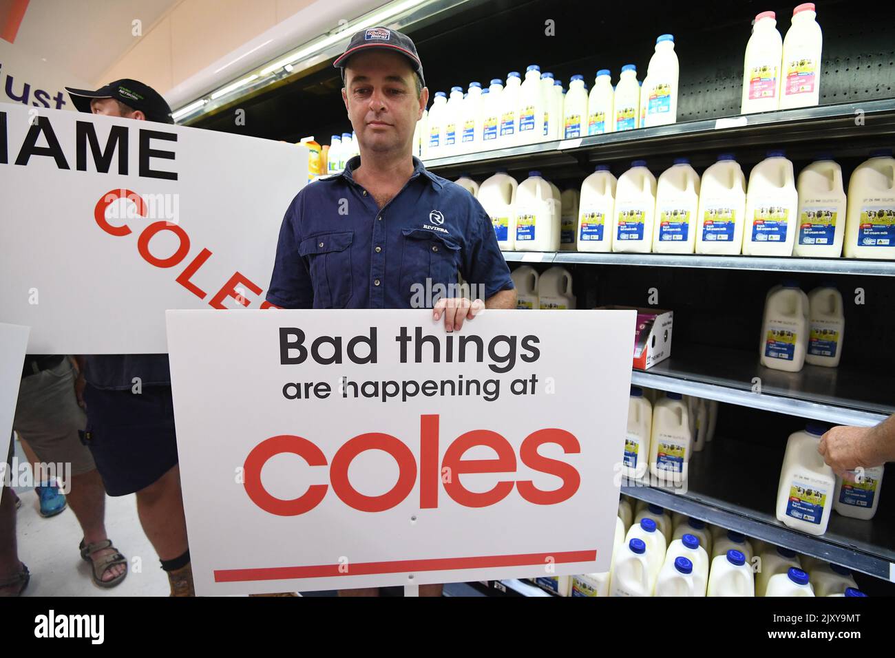 Queensland dairy farmers protest inside a Coles supermarket store in
