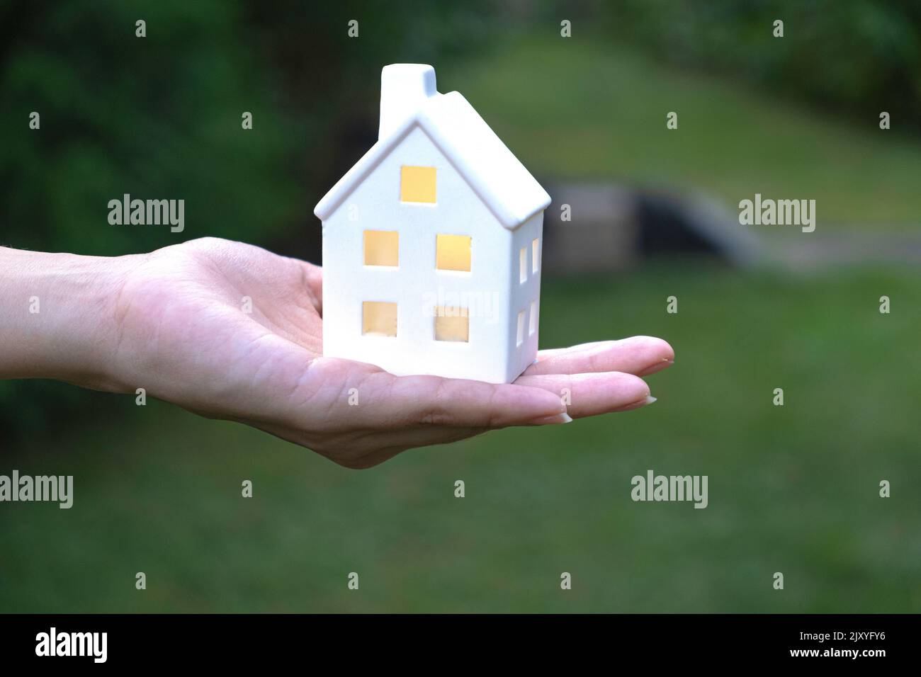 House model in female hand on a green blurred background Stock Photo ...