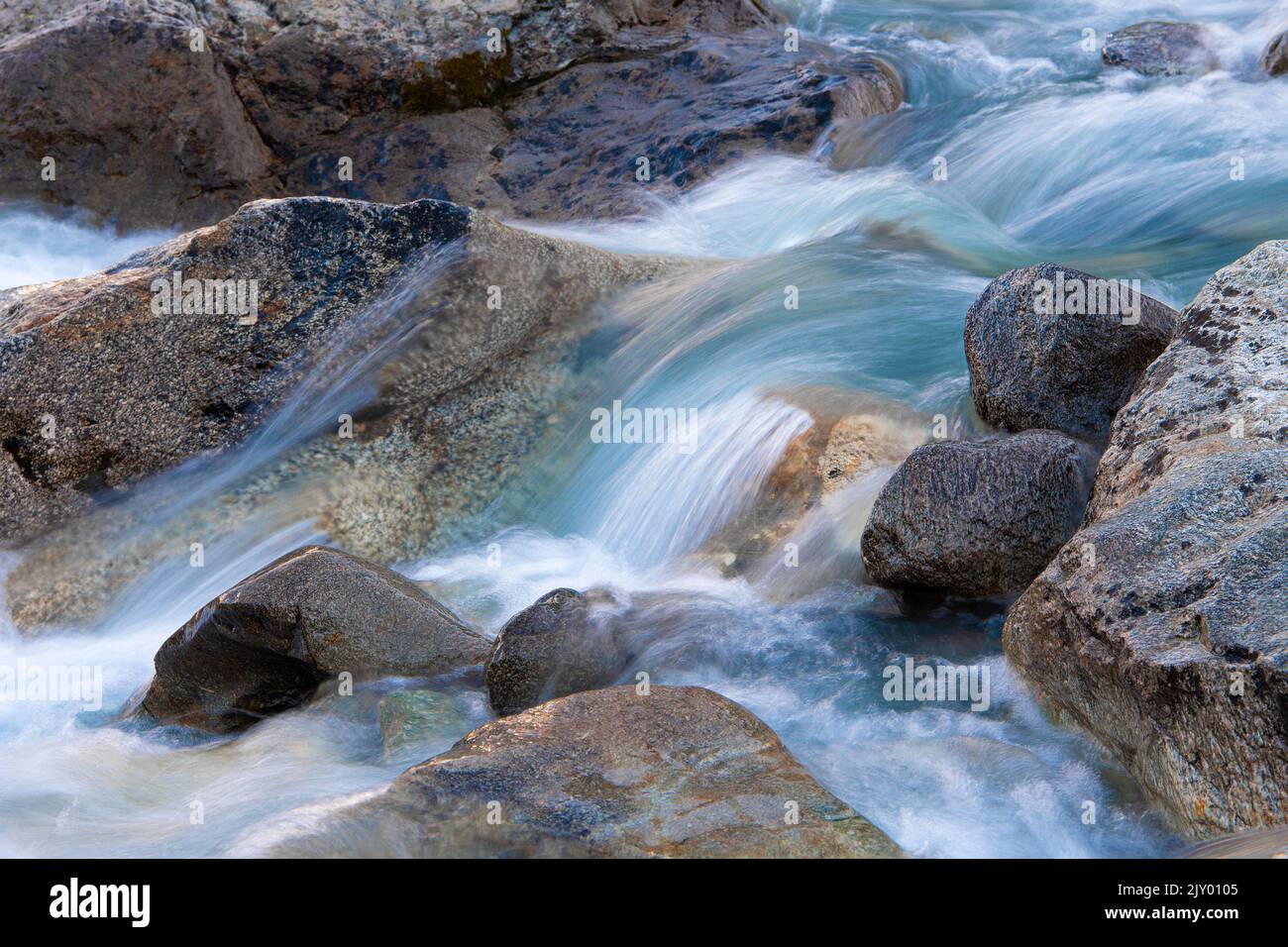 Long time exposure of the flowing water of a creek in the Swiss Alps Stock Photo