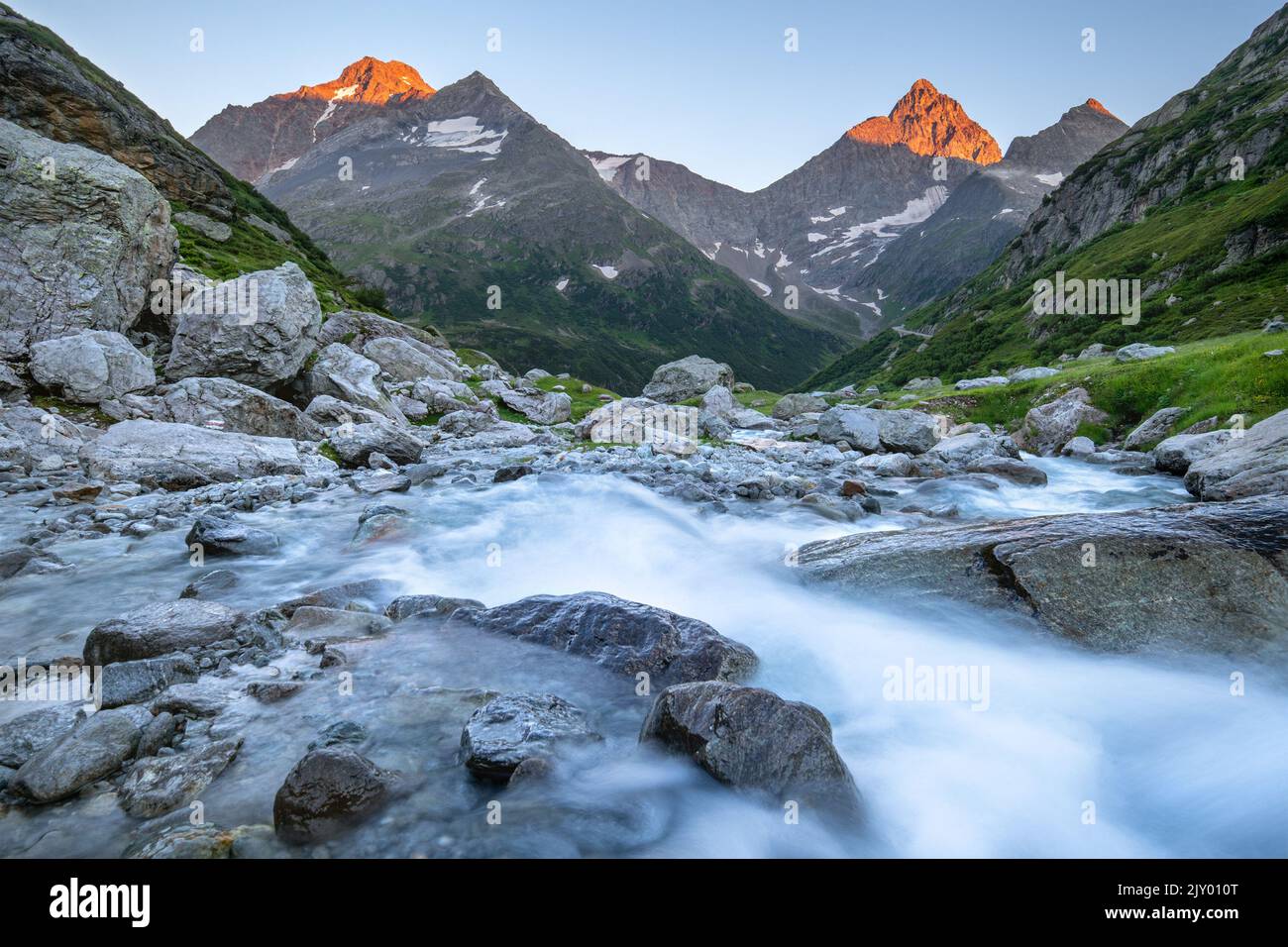 Long time exposure of the flowing water of a creek in the Swiss Alps in the evening Stock Photo