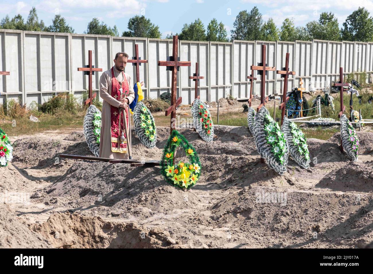 Bucha, Ukraine. 2nd Sep, 2022. A priest is seen conducting a burial ceremony. Burial of the remains of 13 unidentified and two identified people who were killed in the Buchan district during the Russian occupation, on September 2, 2022. A few months after the de-occupation of the Bucha district, those bodies that were not identified were buried and marked with numbers at the cemetery in Bucha. According to the deputy mayor of Buch Mykhailyna Skoryk, a total of 419 people who were killed during the Russian occupation of the Buchan district were buried in the city. (Credit Image: © Mykhaylo Stock Photo