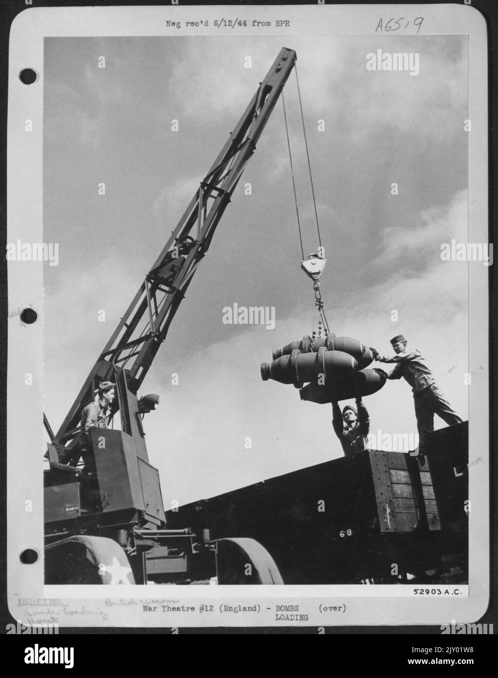 Ordnance crew of the ammunition section are seen unloading 500-pounders from British 'wagons' to be stacked in bomb dump revetments according to size and weight, at bomb supply depot for shipment to various airdromes in England. Stock Photo