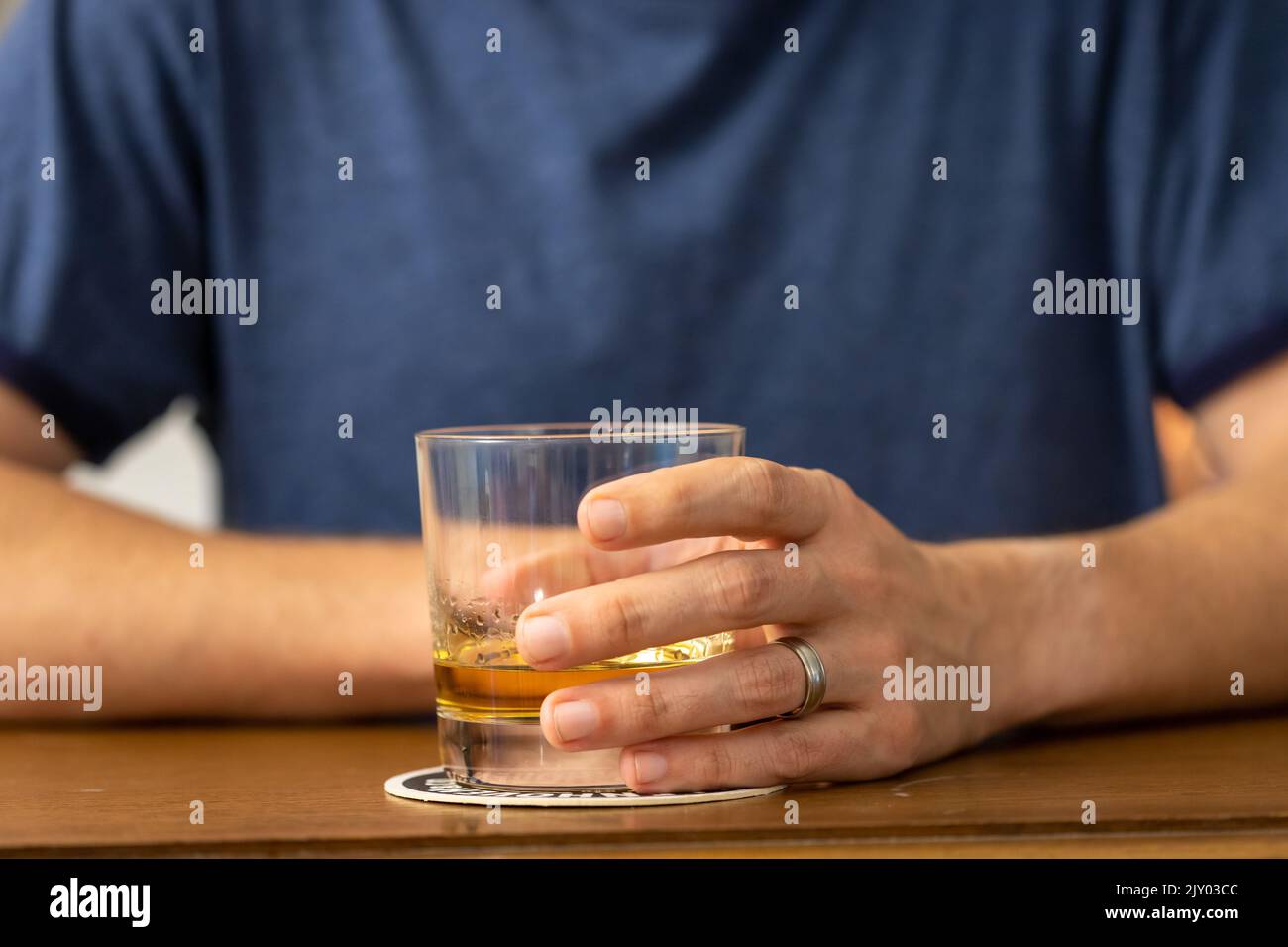 Man Holding a Whiskey Glass at a Bar Stock Photo