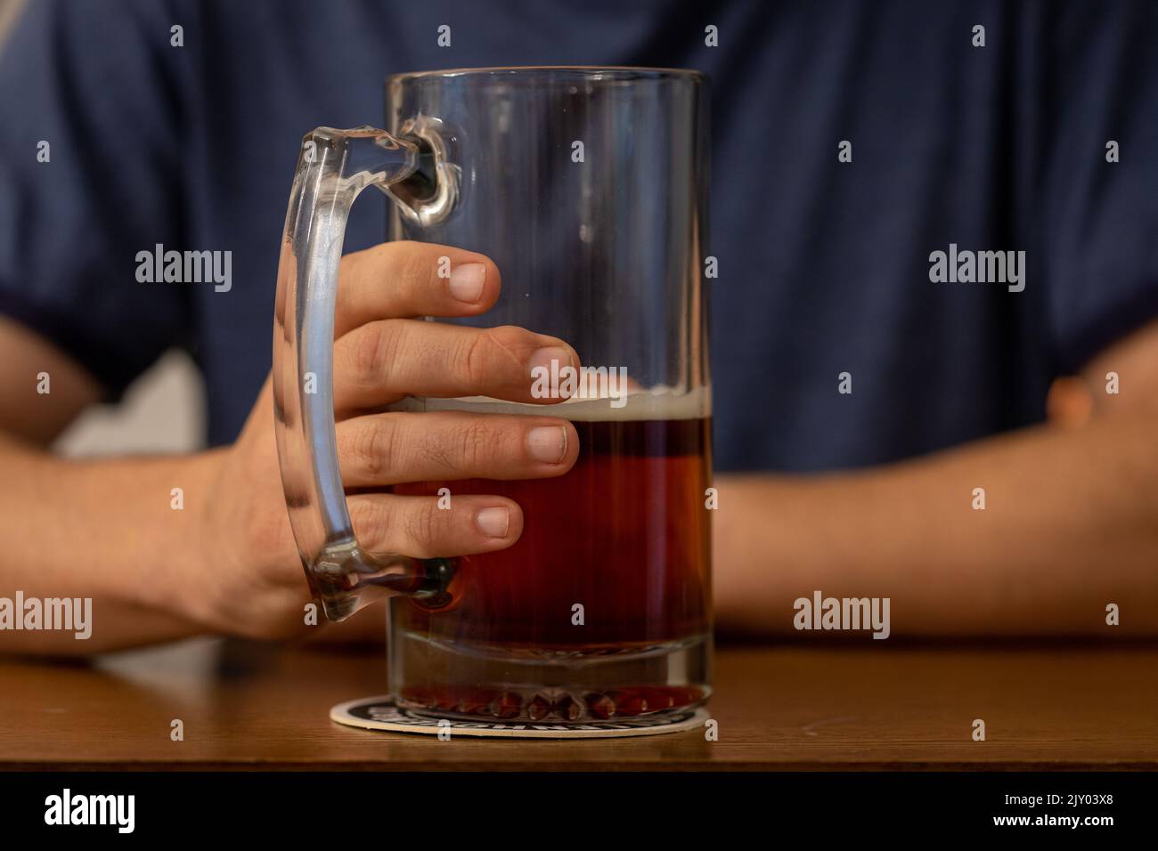 Close-up of Man's Hand Holding a Stein of Beer Stock Photo