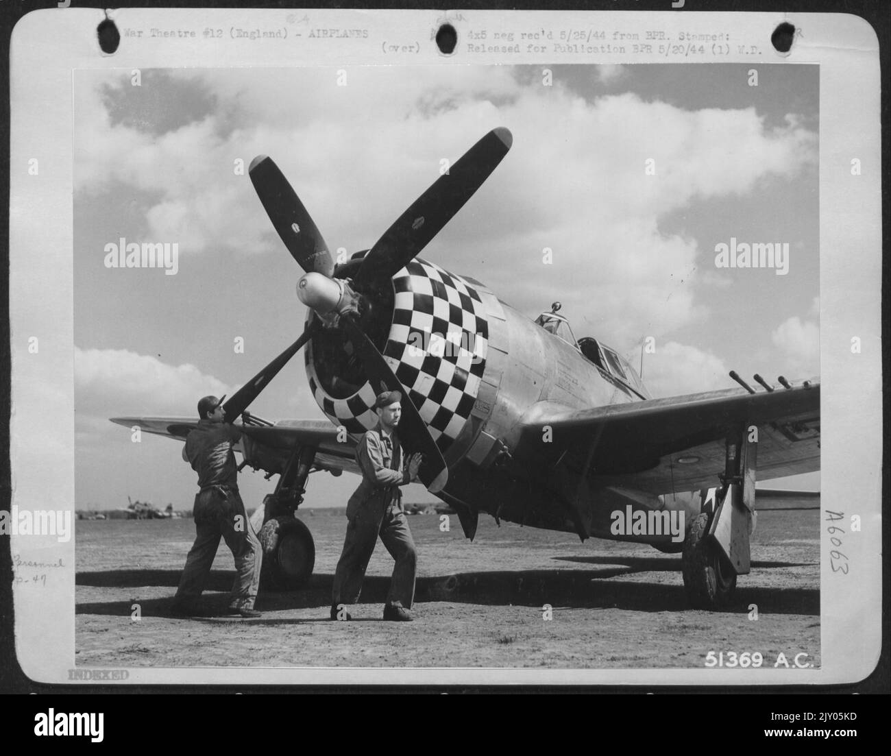 PULLIN PROP THRU. .. Preparatory to starting engine of P-47 Thunderbolt piloted by Capt. Qunice L. Brown, leading fighter pilot with 13 kills to his credit, Crew chief T/Sgt. Bill C. Jensen of Superior, Neb., (left) and Asst., crew chief Cpl. Stock Photo