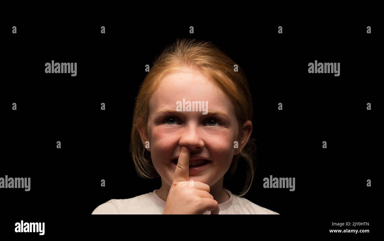 Red headed Caucasian girl with her finger up her nose. Stock Photo