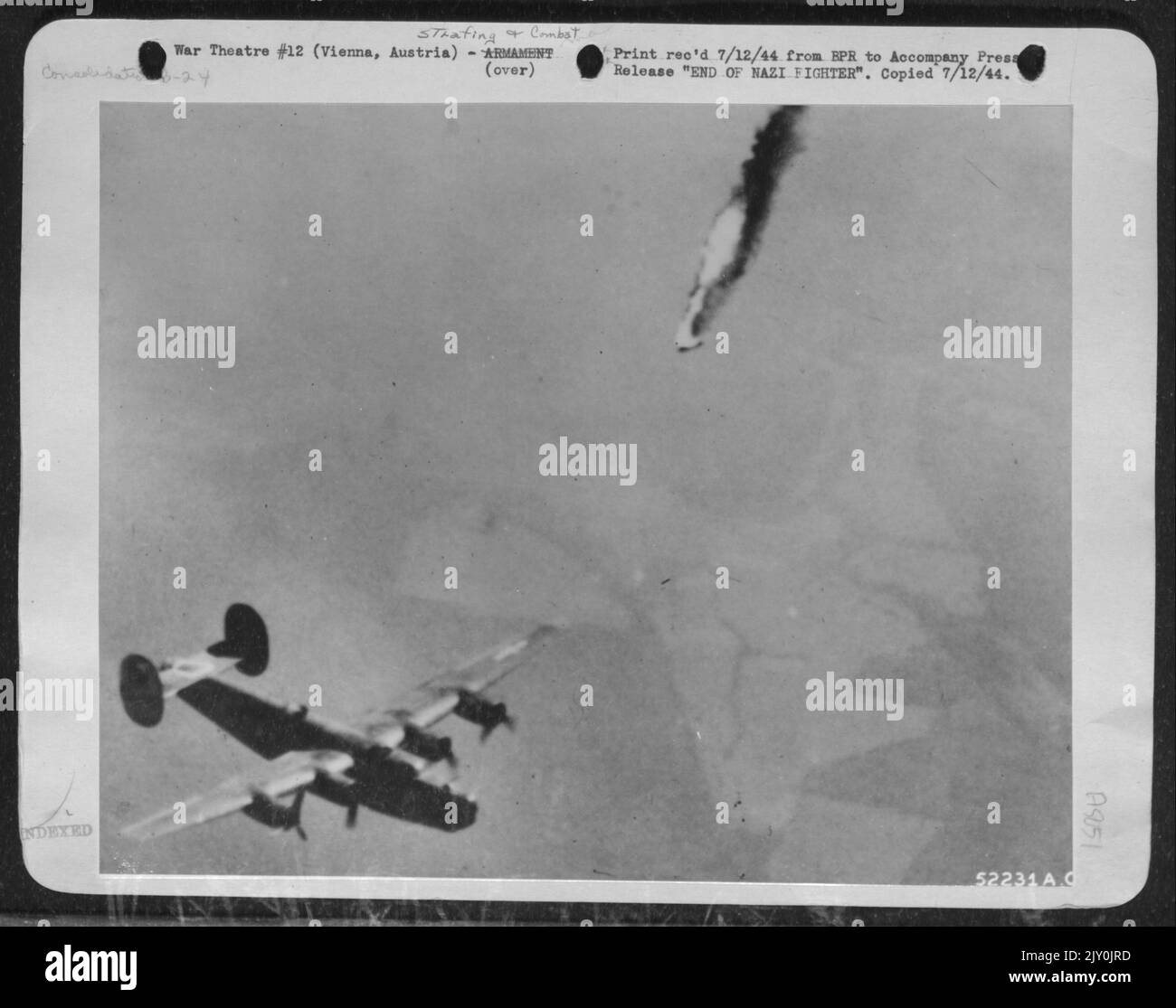 A flaming Messerschmitt 109 Nazi fighter begins a series of dizzy spins as it plunges earthward. The Luftwaffe pilot attempted to pounce on Consolidated B-24 Liberators of the U.S. Army 15th Air force over Vienna, Austria, and was hurriedly disposed Stock Photo