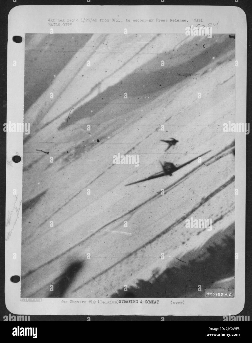 This unusual photograph of a Luftwaffe pilot jumping from his damaged plane was made by Major James Dalglish, Rome, N.Y., a U.S. 9th Air force fighter-bomber pilot, during a recent air battle over the Belgian Bulge. The enemy pilot deserted his ship Stock Photo