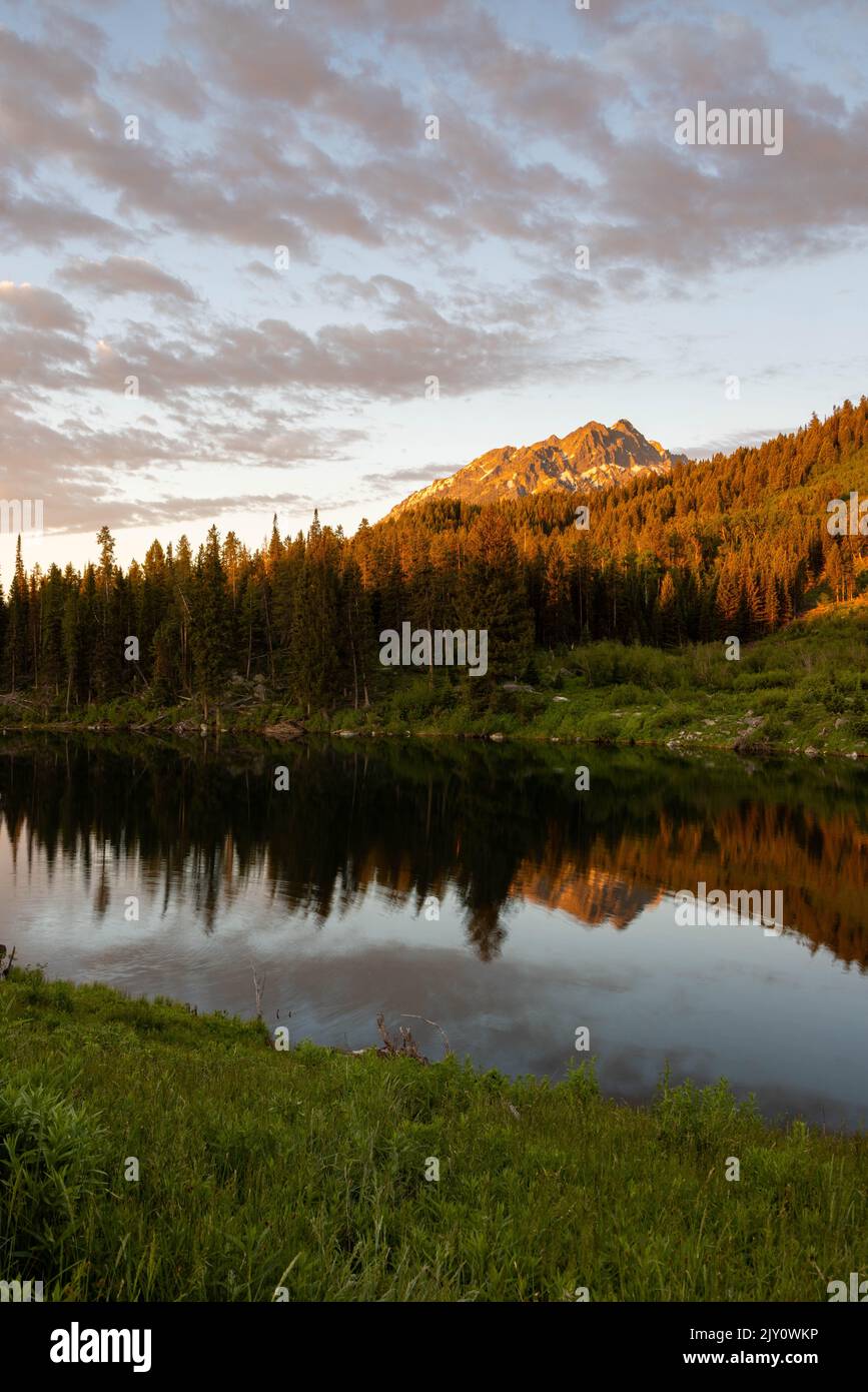 Morning clouds lit with sunrise light passing over Trapper Lake and the