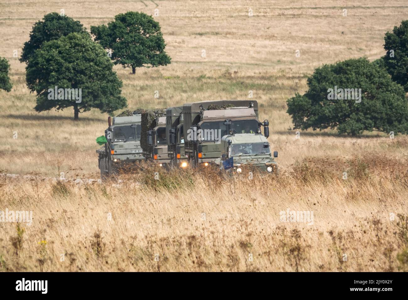 convoy of British army MAN HX60 4x4 & HX58 6x6 Heavy Utility Trucks in action on a military exercise Stock Photo