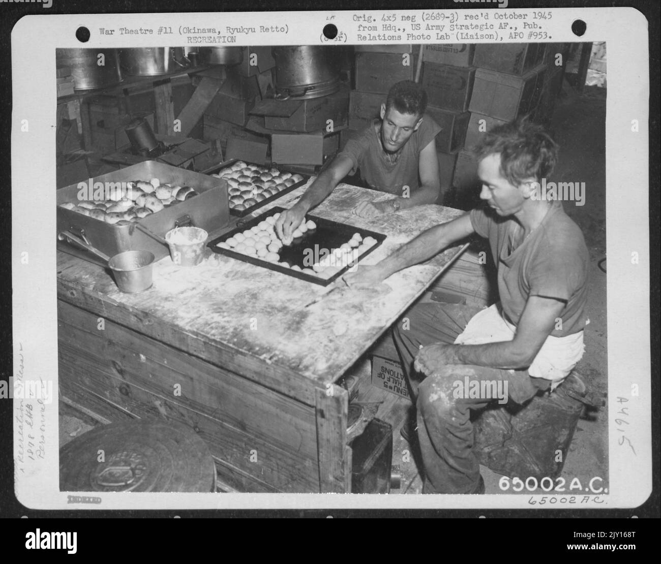 Two Bakers Of The 1878Th Engineering Aviation Battalion Preparing Biscuits For The Oven. They Are Left To Right: T/5 Aster A. Harris, 34 River Street, Cliff Side, North Carolina, And T/4 Virgil A. Richardson, 210 North Mulburry Street, Spencerville, Ohio Stock Photo