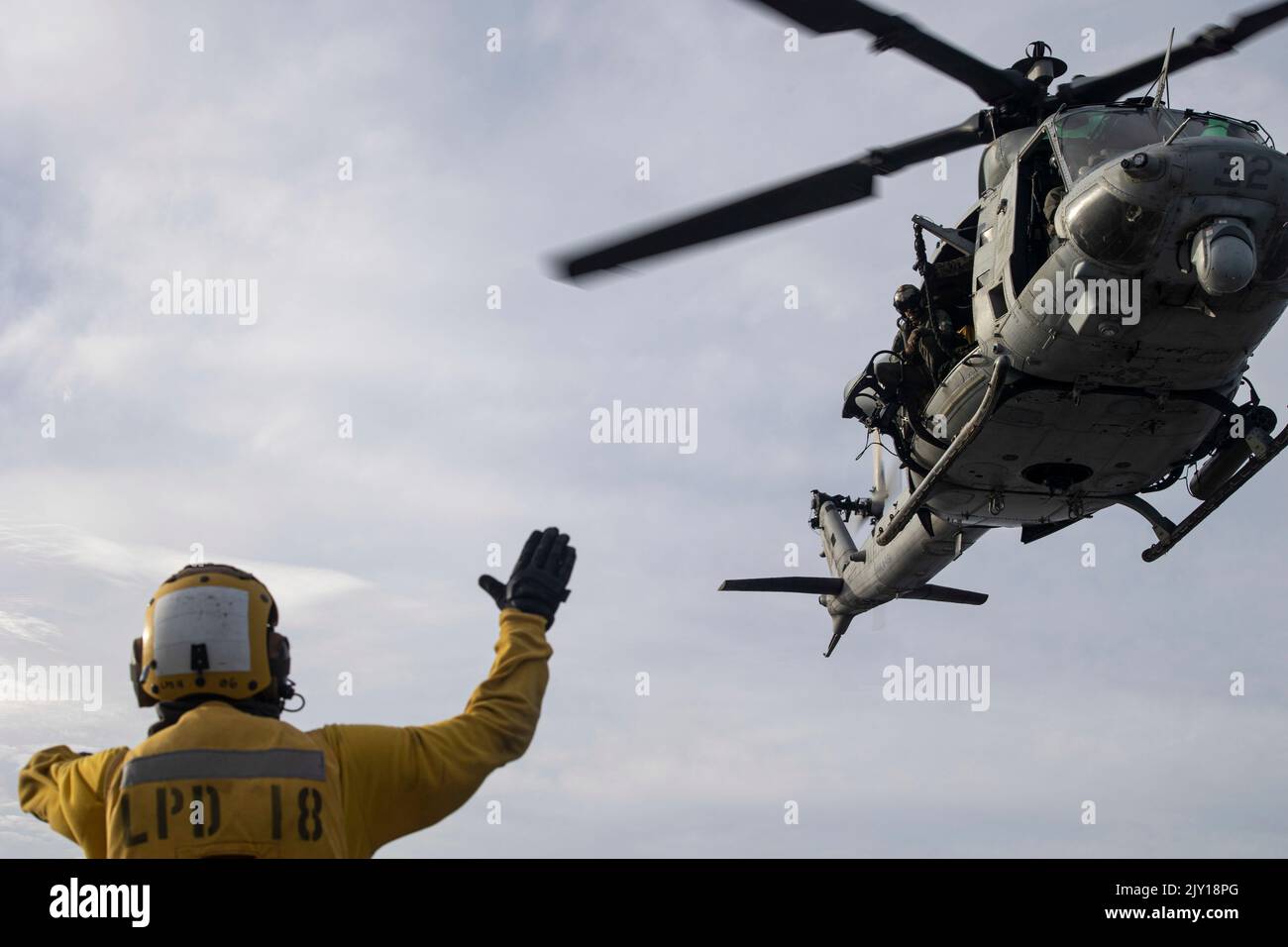 A U.S. Navy Sailor assigned to USS New Orleans (LPD 18) signals to Marines with Marine Medium Tiltrotor Squadron 262 (Rein.), 31st Marine Expeditionary Unit, during fast rope training aboard LPD 18 in the Sea of Japan, Sept. 5, 2022. Fast roping allows for fast inserts in a contested area. The 31st MEU is operating aboard ships of the Tripoli Amphibious Ready Group in the 7th fleet area of operations to enhance interoperability with allies and partners and serve as a ready response force to defend peace and stability in the Indo-Pacific Region. (U.S. Marine Corps photo by Sgt. Danny Gonzalez) Stock Photo
